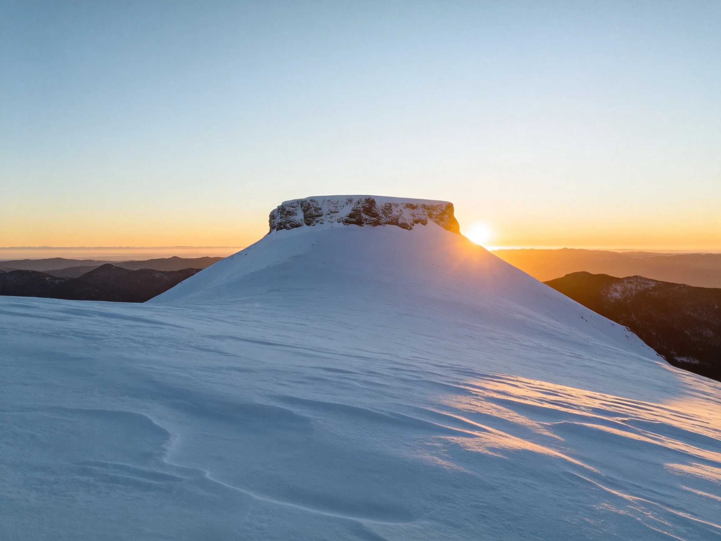 Snow-Capped Summit Rock Formation at Sunset Overlooking Valleys