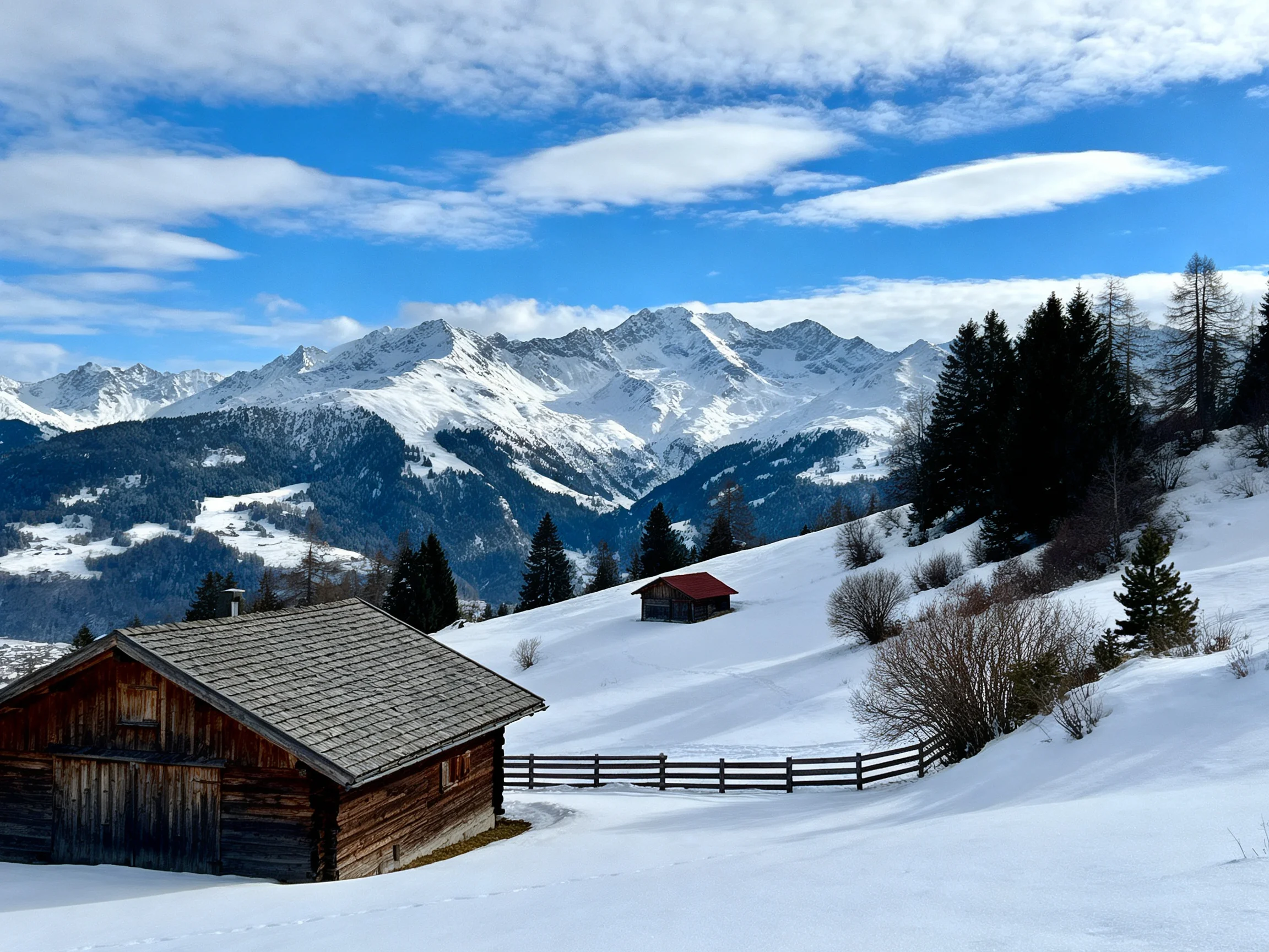 Snow-covered mountain slopes with rustic wooden cabins and pine forests