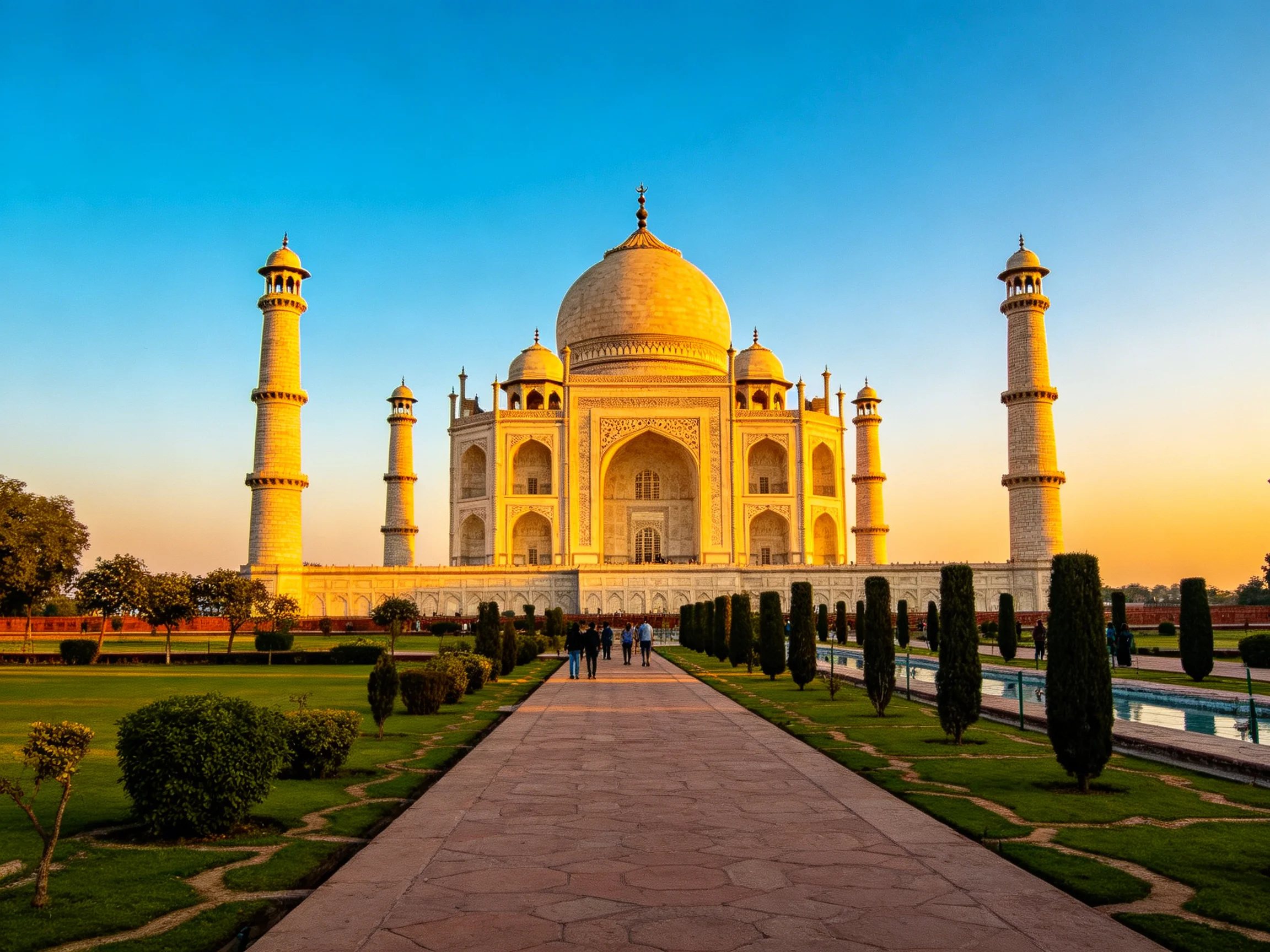 Taj Mahal glowing in golden sunset light with four minarets
