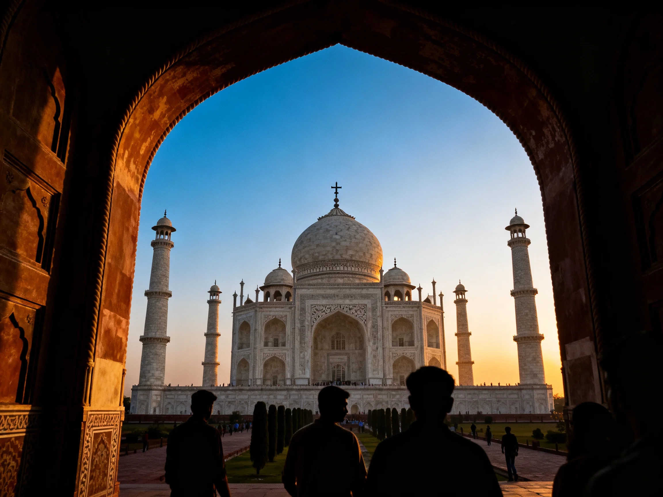 Taj Mahal viewed through an ornate stone archway at sunset