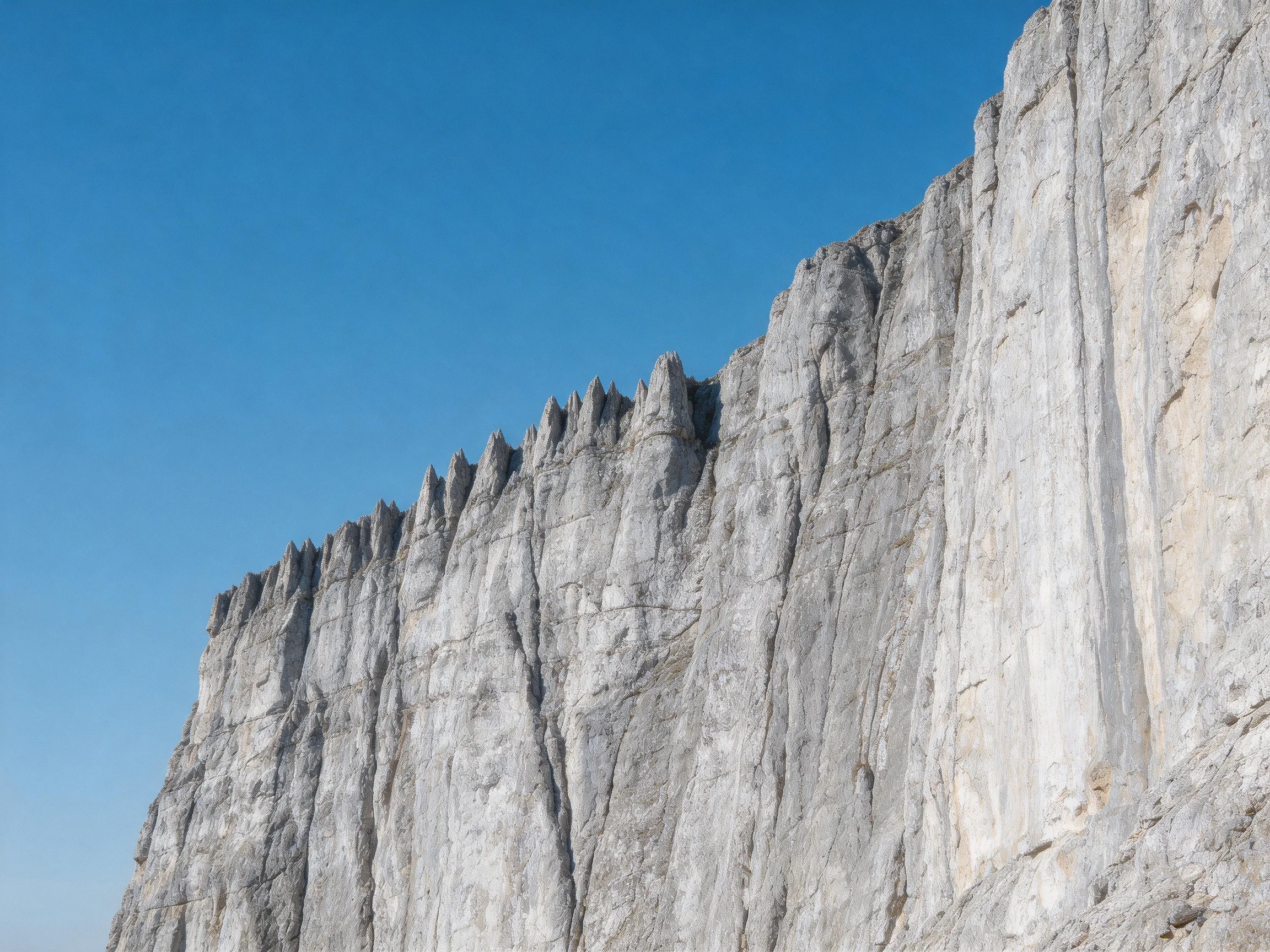 Tall gray limestone cliffs against a clear blue sky