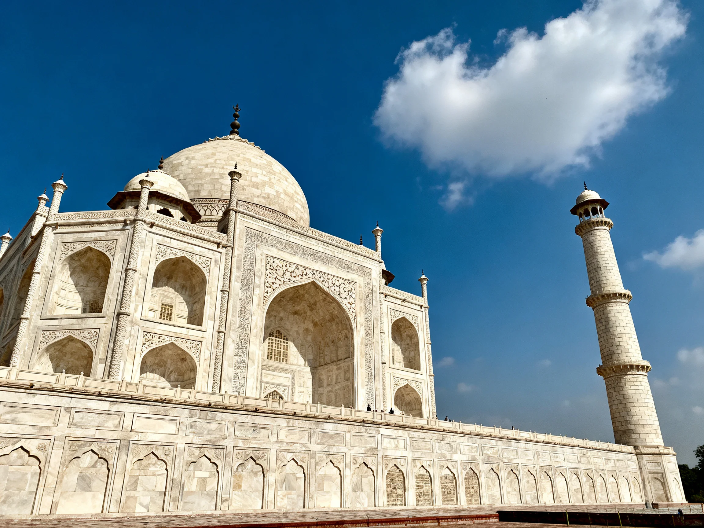 The Taj Mahals White Marble Structure with Minaret Under Bright Blue Sky
