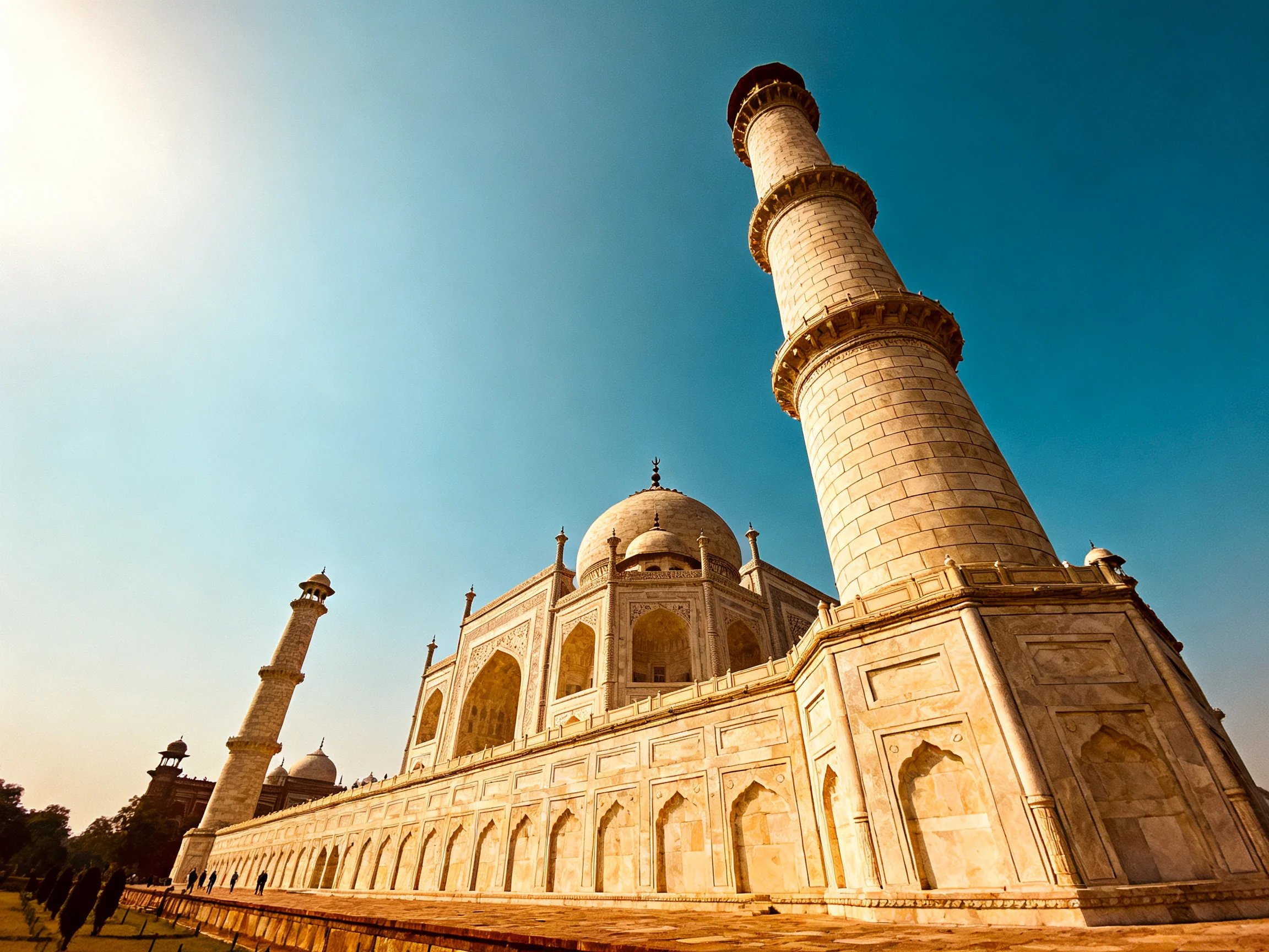 The Taj Mahals magnificent marble architecture with tall minarets under clear blue sky