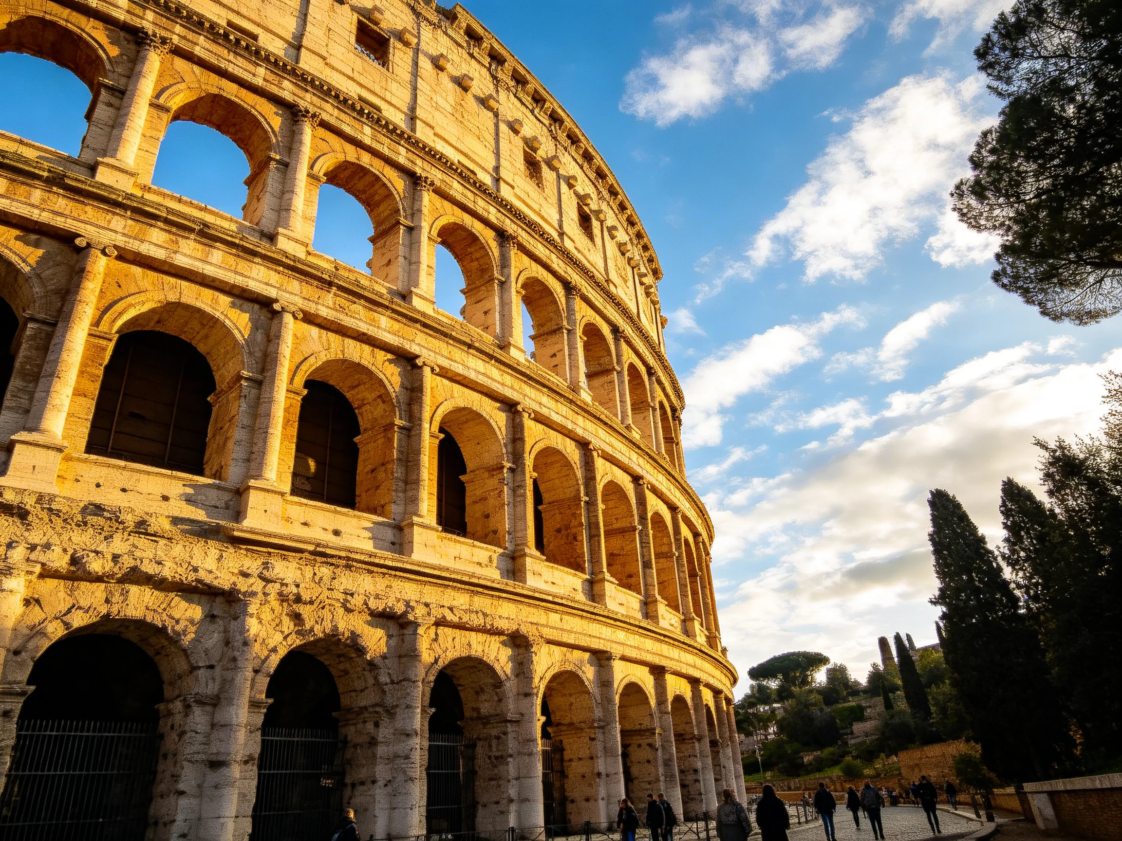 The ancient Colosseum bathed in golden sunlight against a blue sky