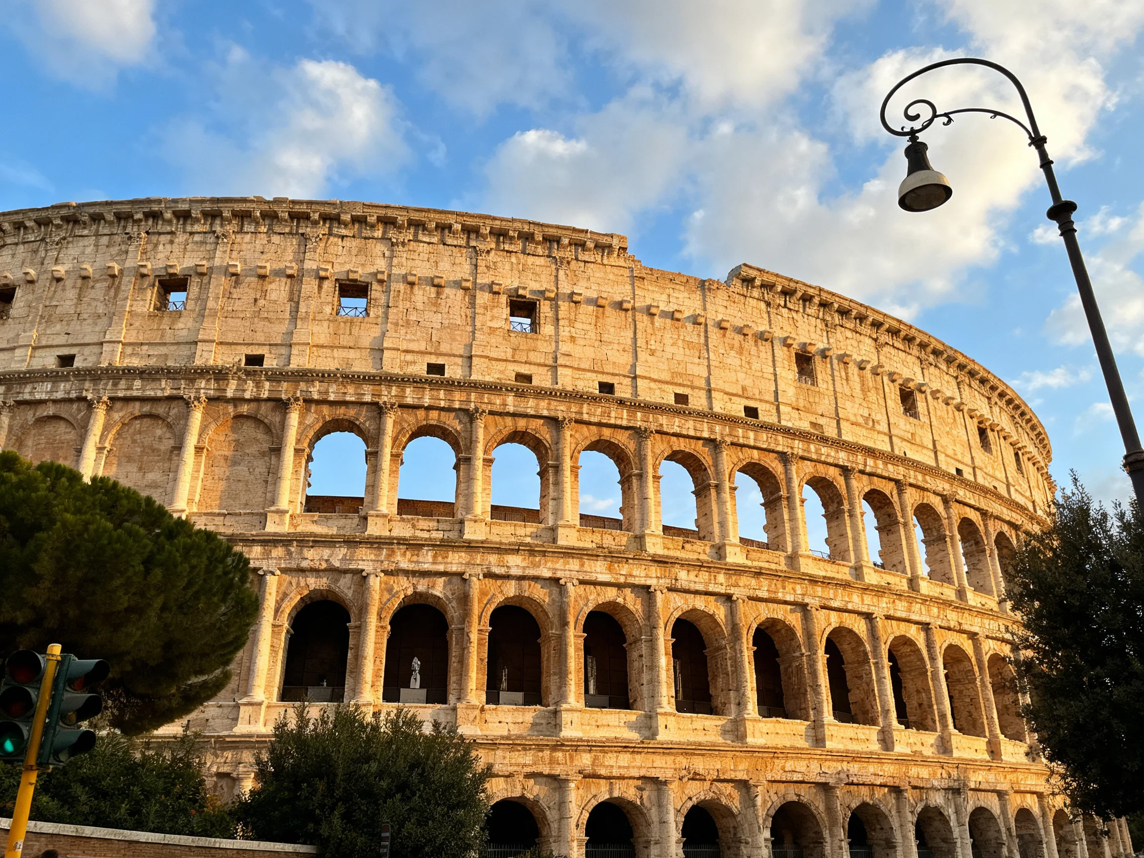 The ancient Colosseum illuminated by golden sunlight against a blue sky