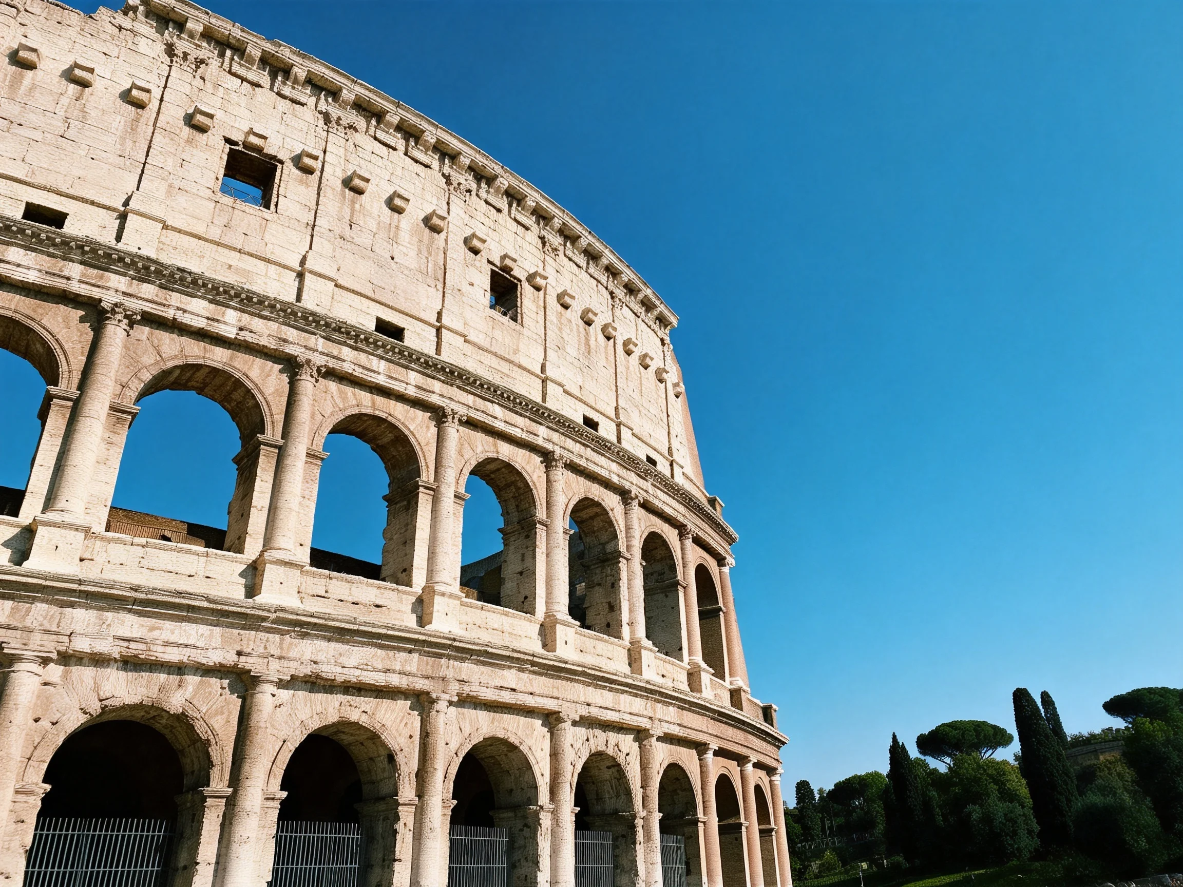 The ancient Colosseum with weathered stone arches under clear blue sky