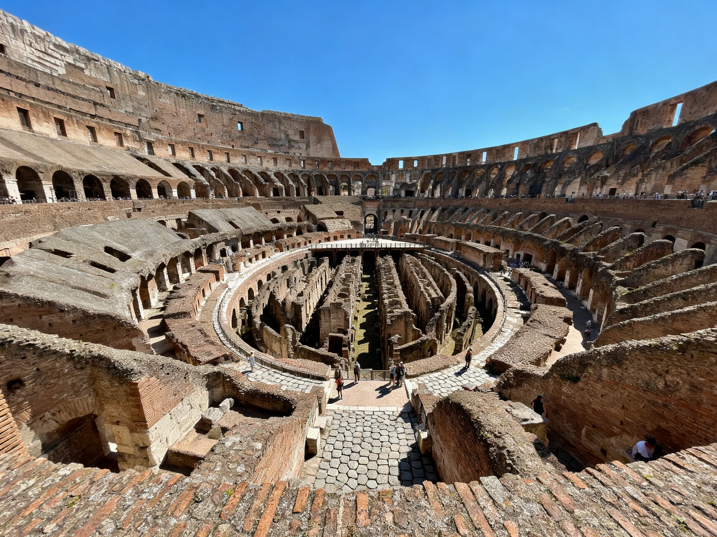 The ancient Colosseums weathered brick amphitheater under clear blue sky