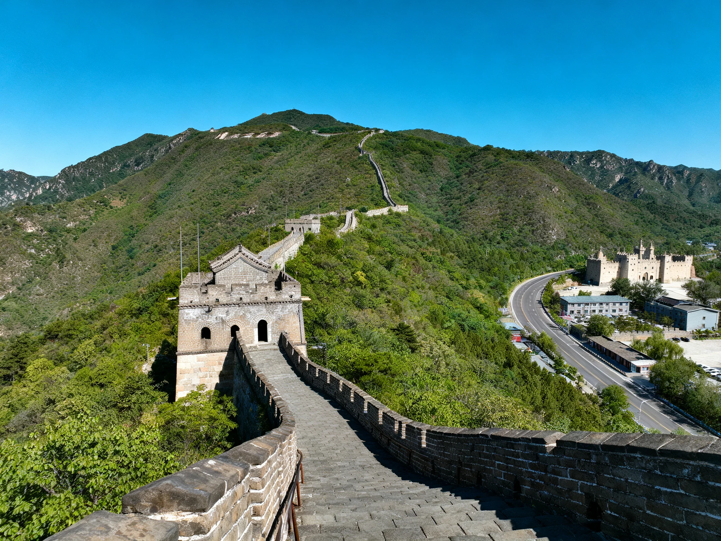 The ancient stone Great Wall winds along lush green mountainside