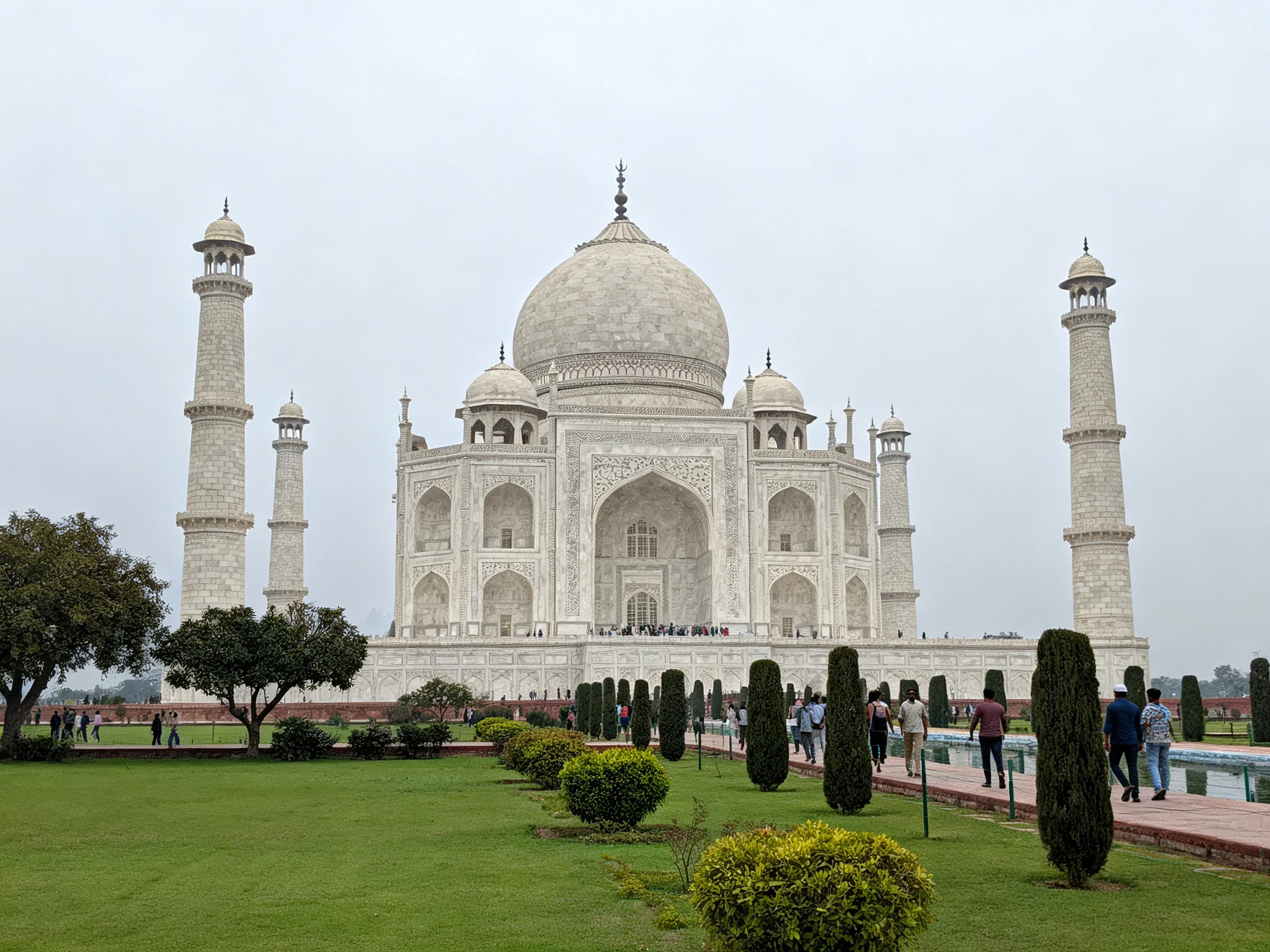 The majestic white marble Taj Mahal with four towering minarets and well-maintained gardens