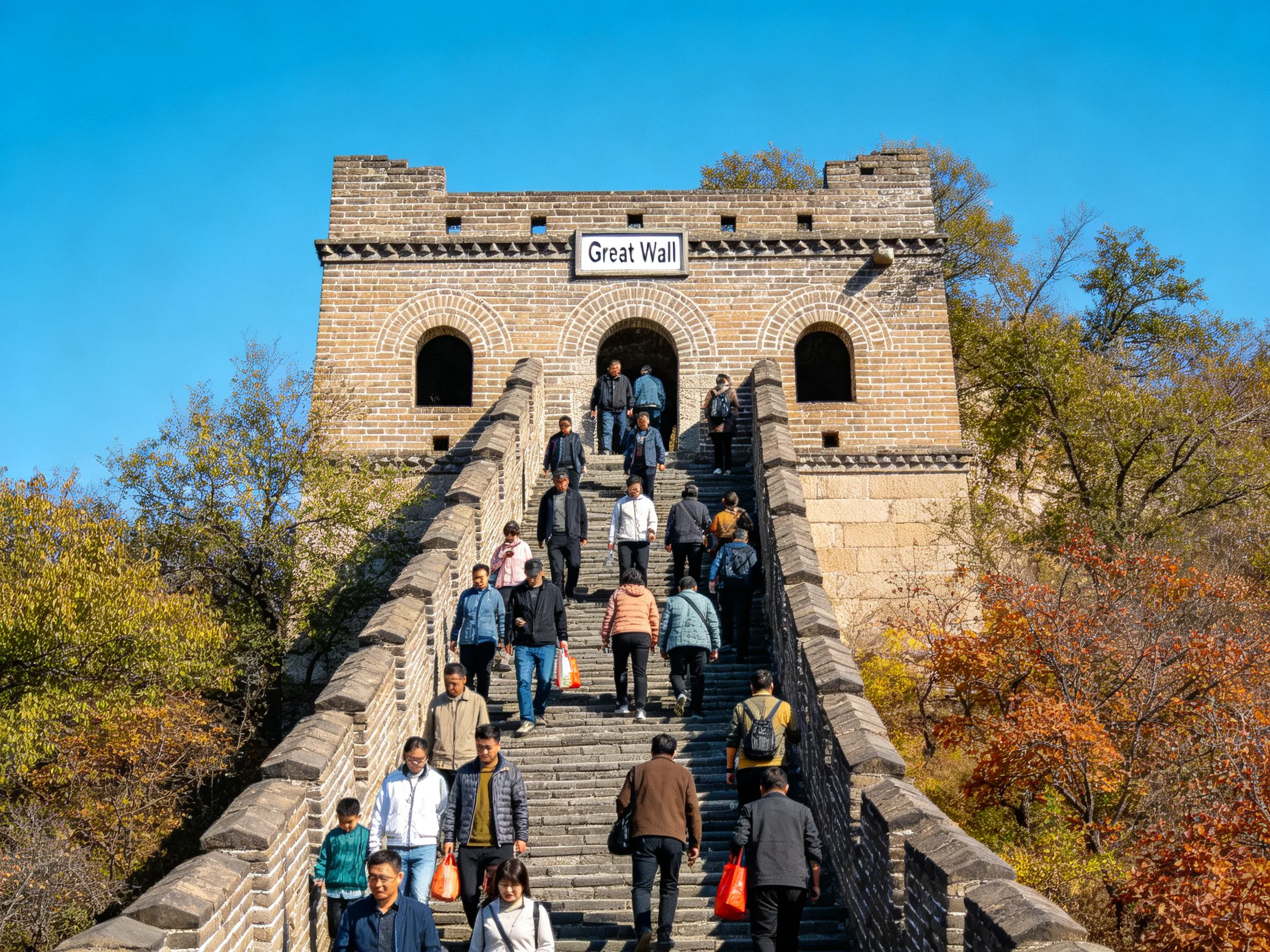 Tourists climbing ancient stone Great Wall with autumn foliage