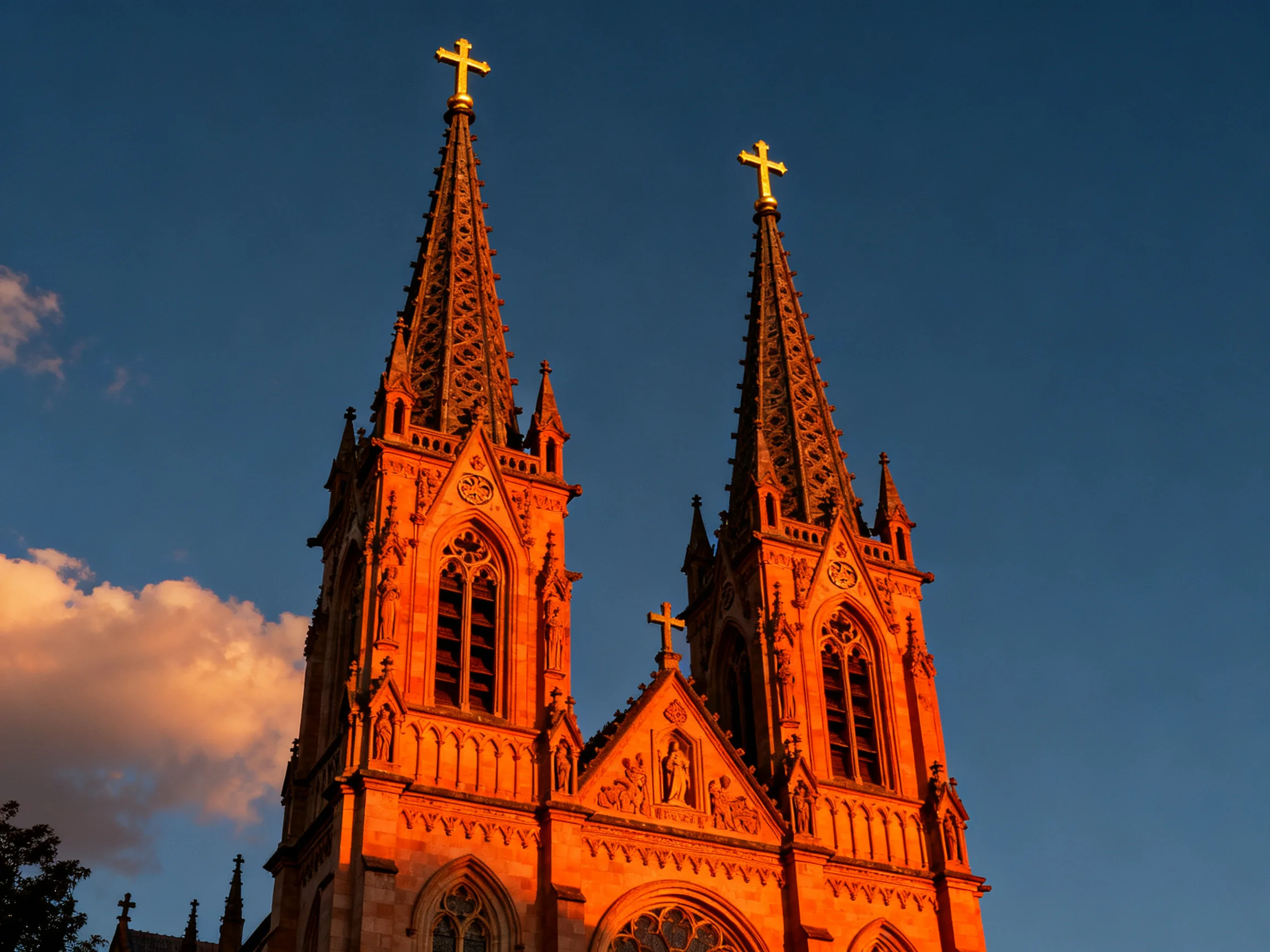 Twin Gothic church spires with golden crosses under deep blue sky