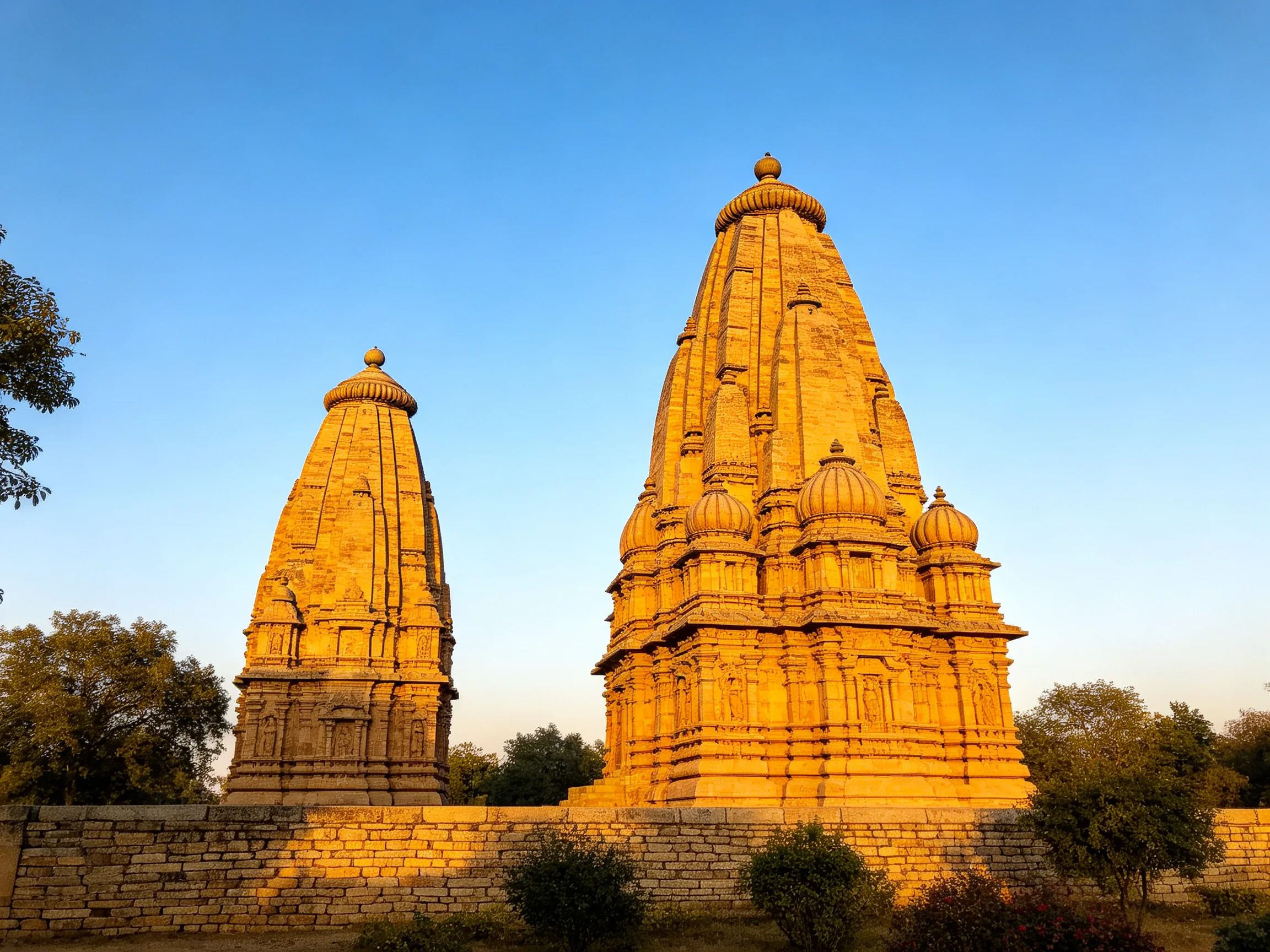 Two ancient stone temples bathed in golden sunlight