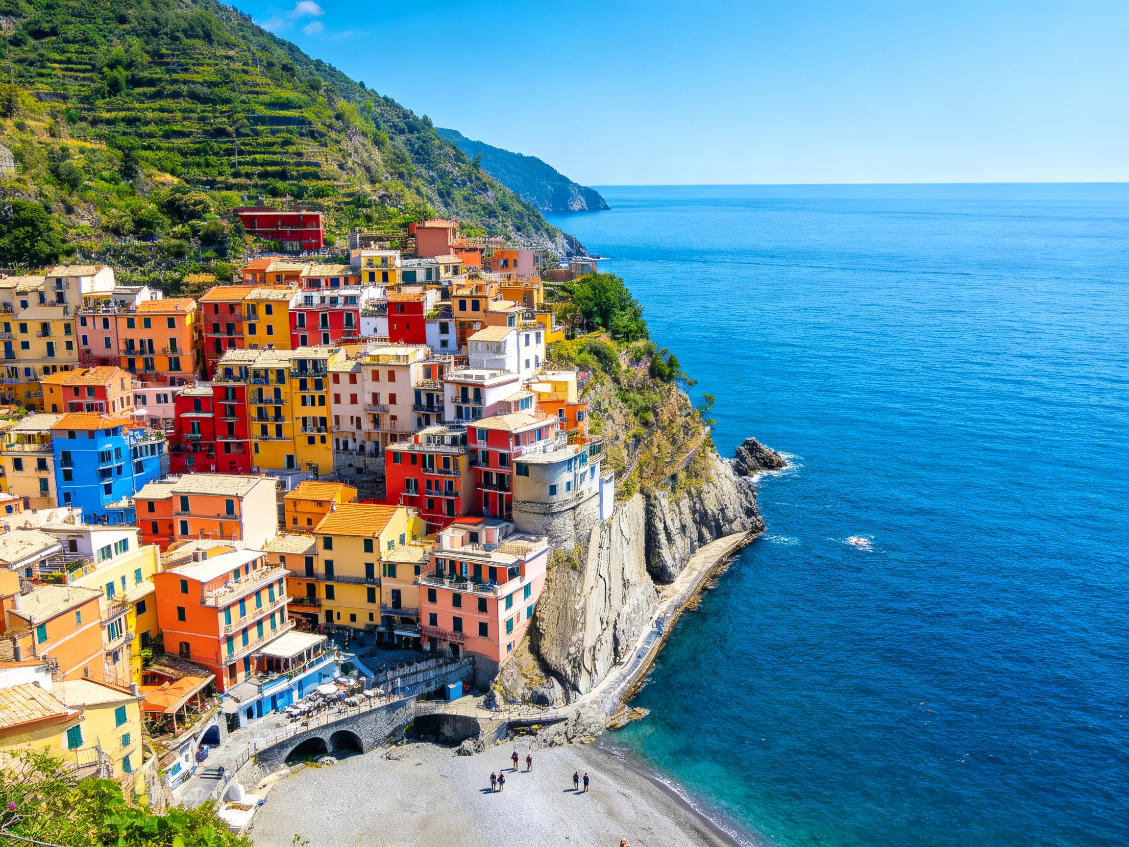 Vibrant multicolored village clings to steep rocky coastline by deep blue sea