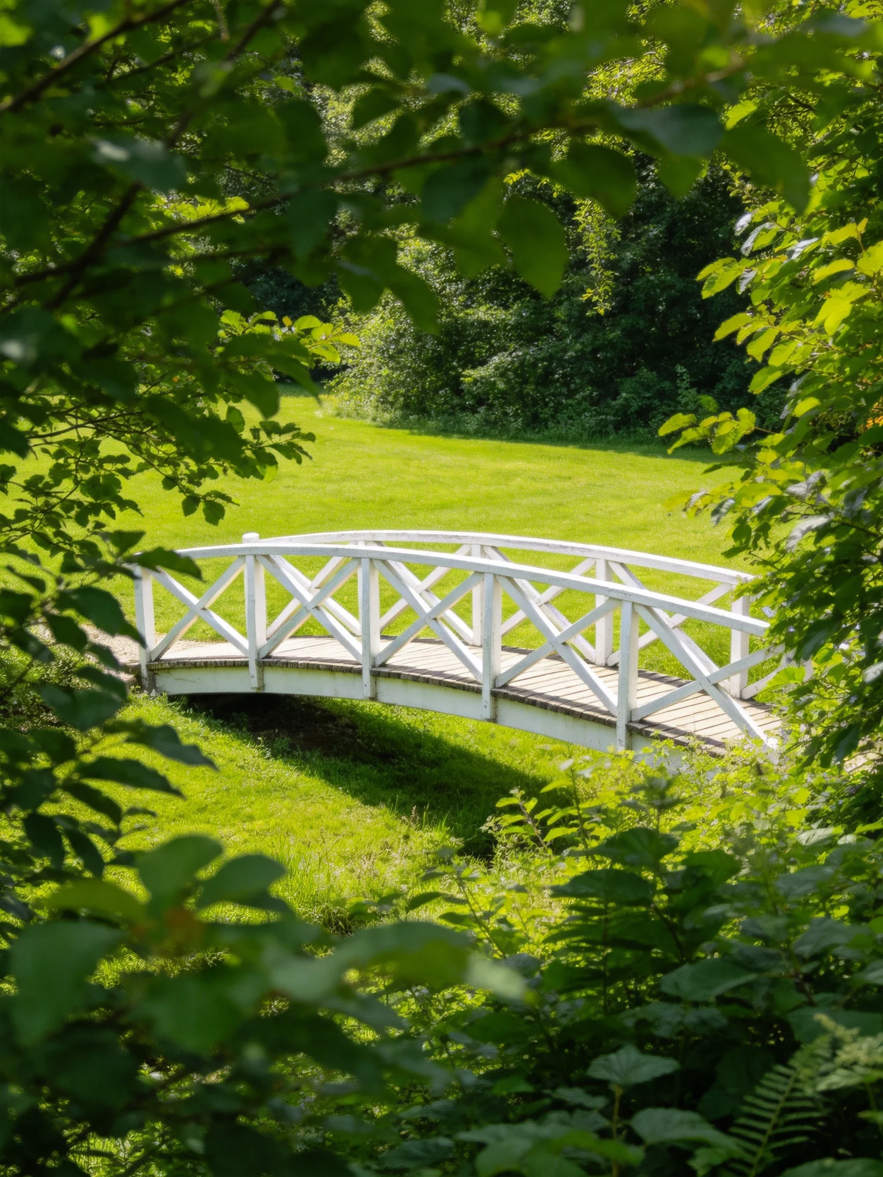 A white wooden bridge spans a grassy area amid lush greenery