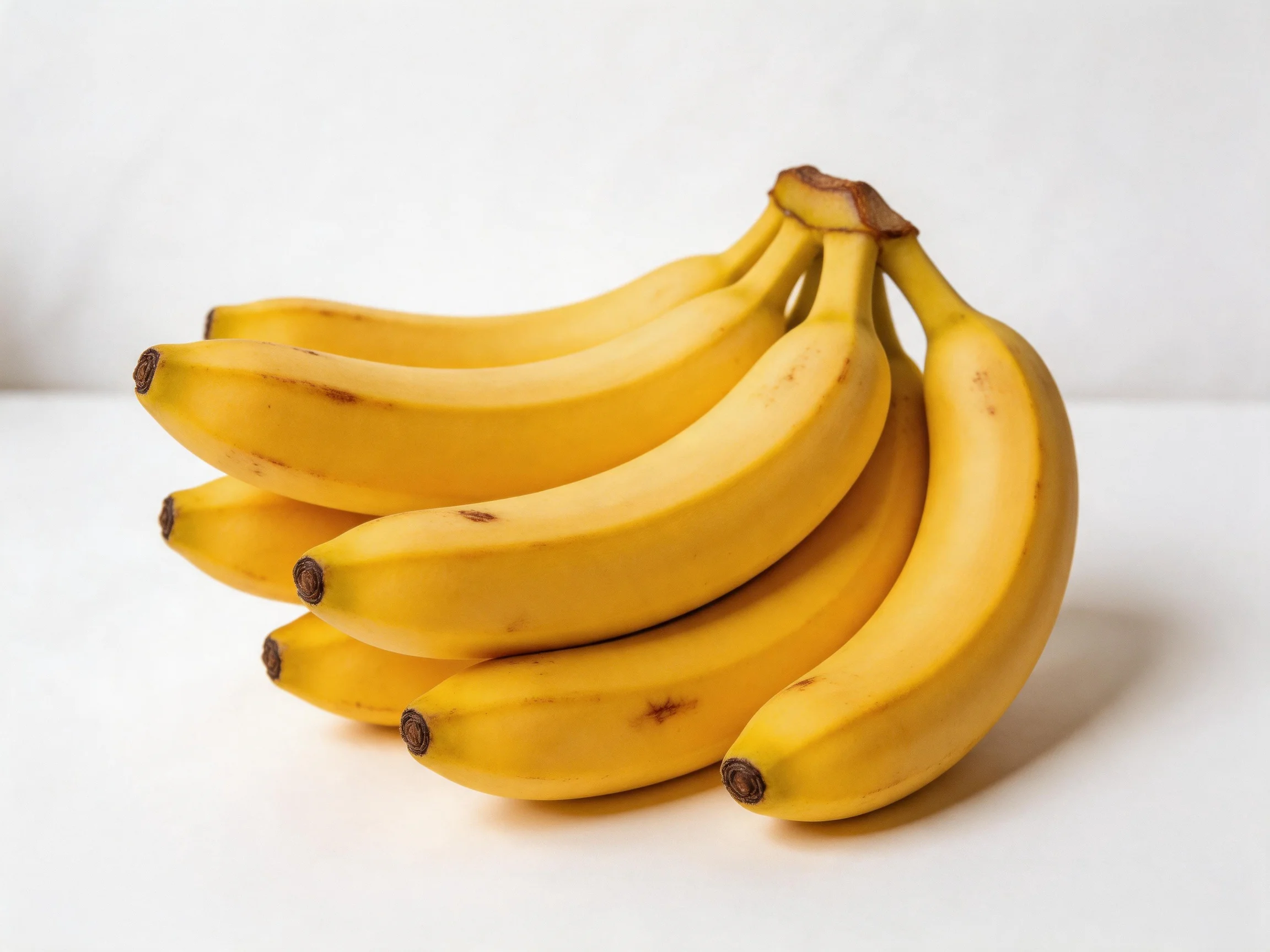 A cluster of golden-yellow bananas grouped closely together