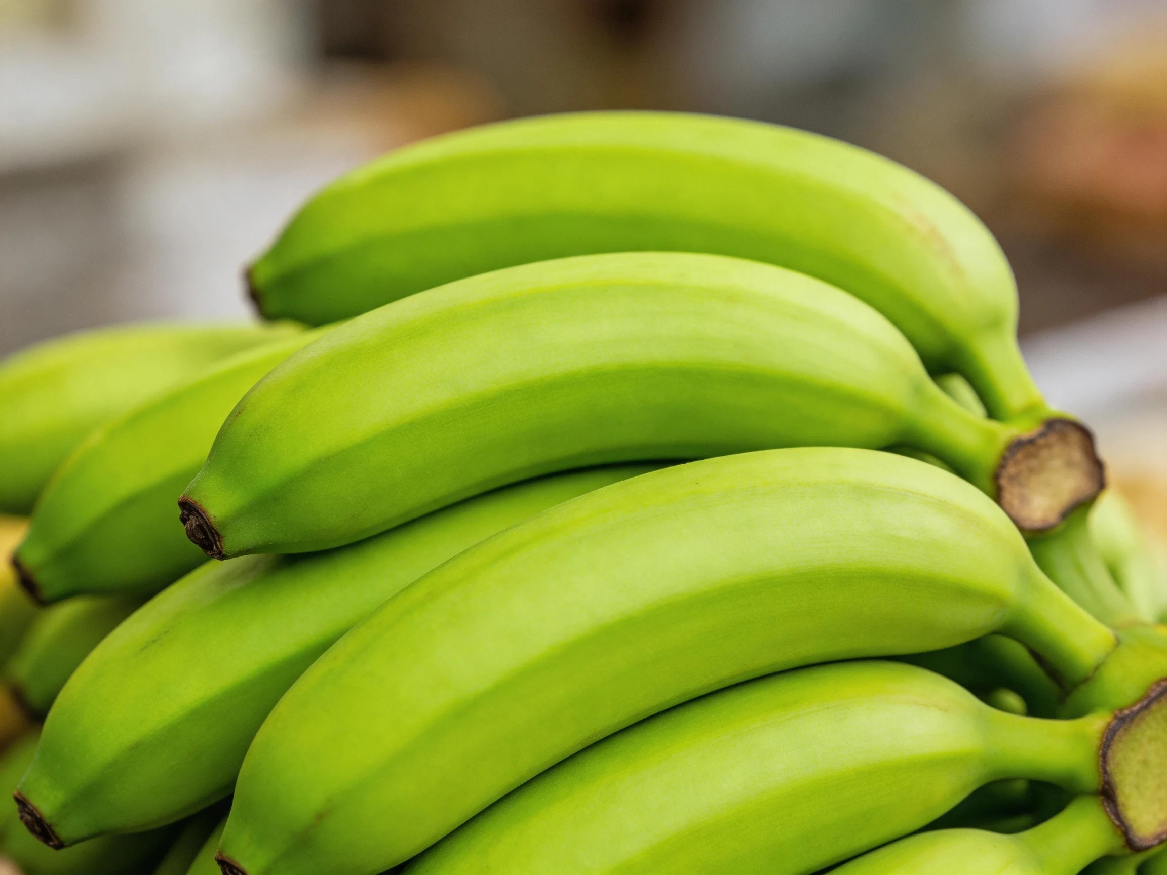 A cluster of vibrant green bananas stacked closely together