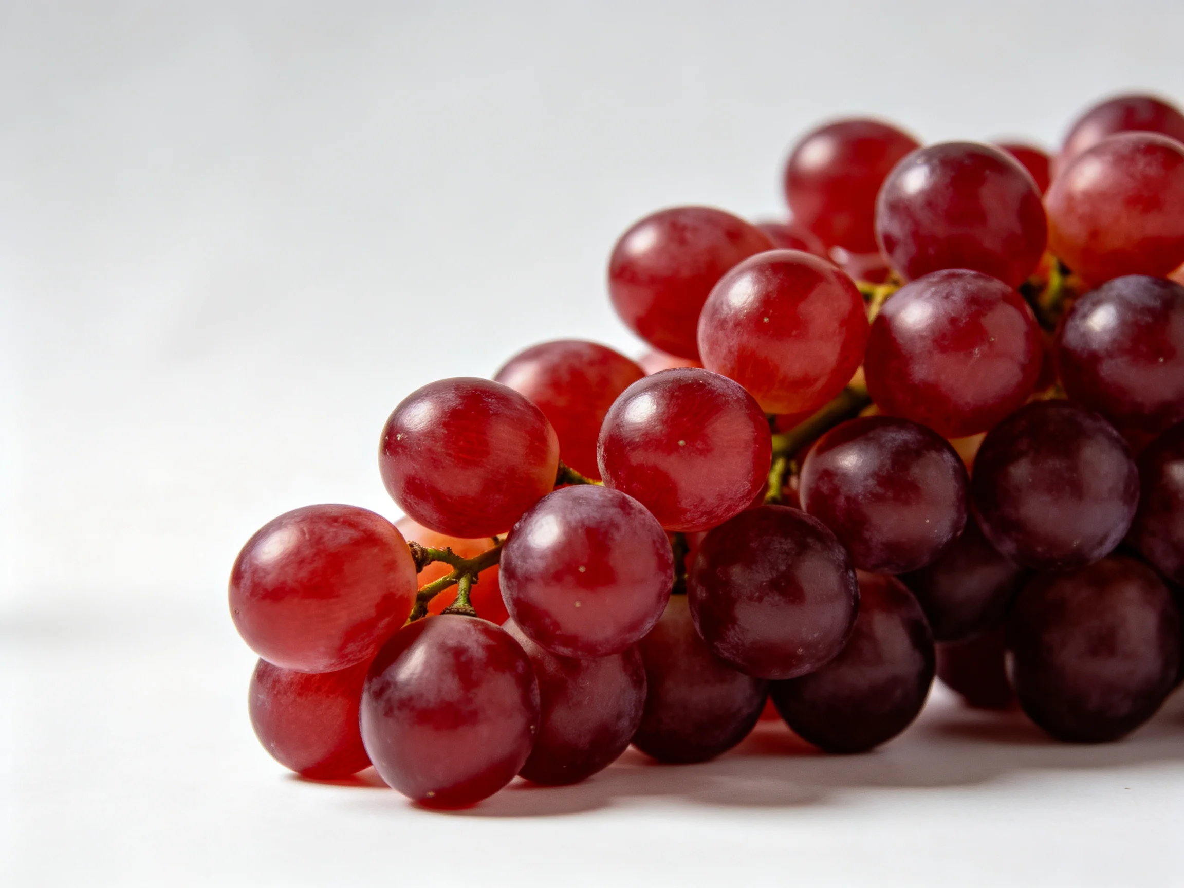 A cluster of vibrant red and deep purple grapes arranged closely