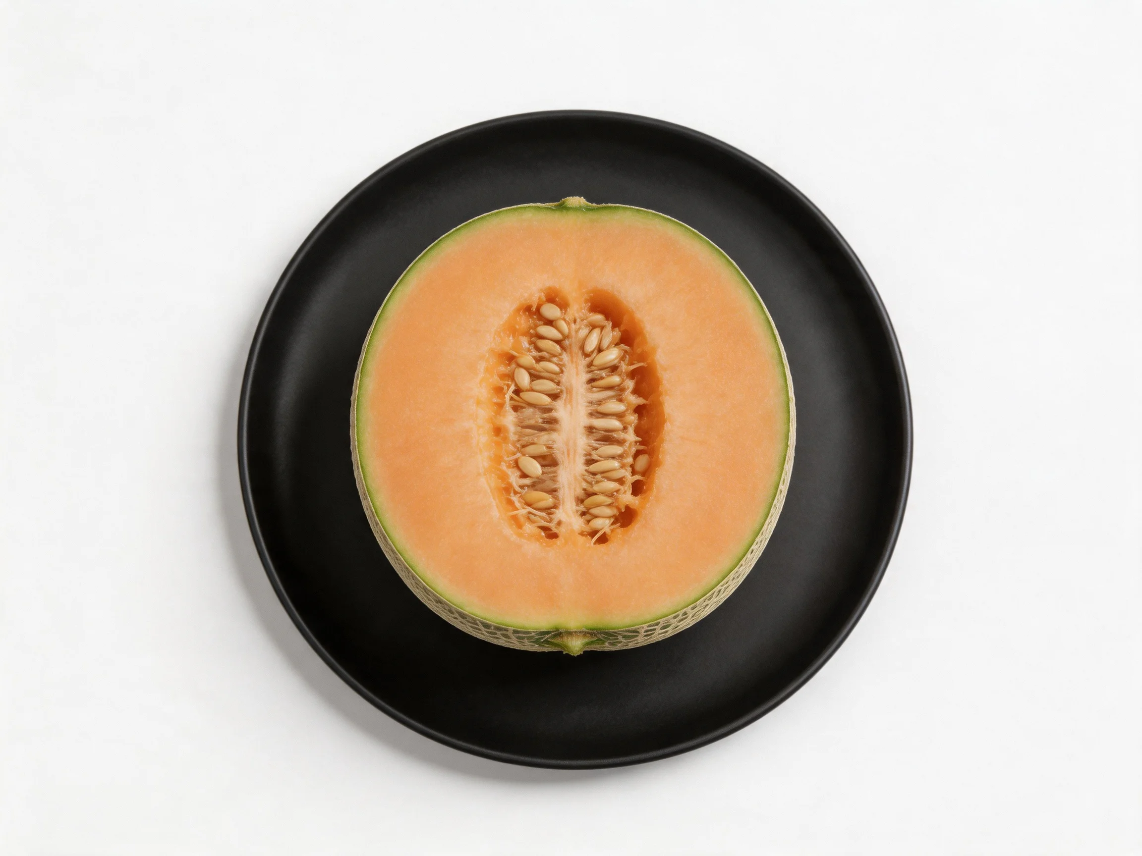 A halved orange cantaloupe rests on a matte black plate