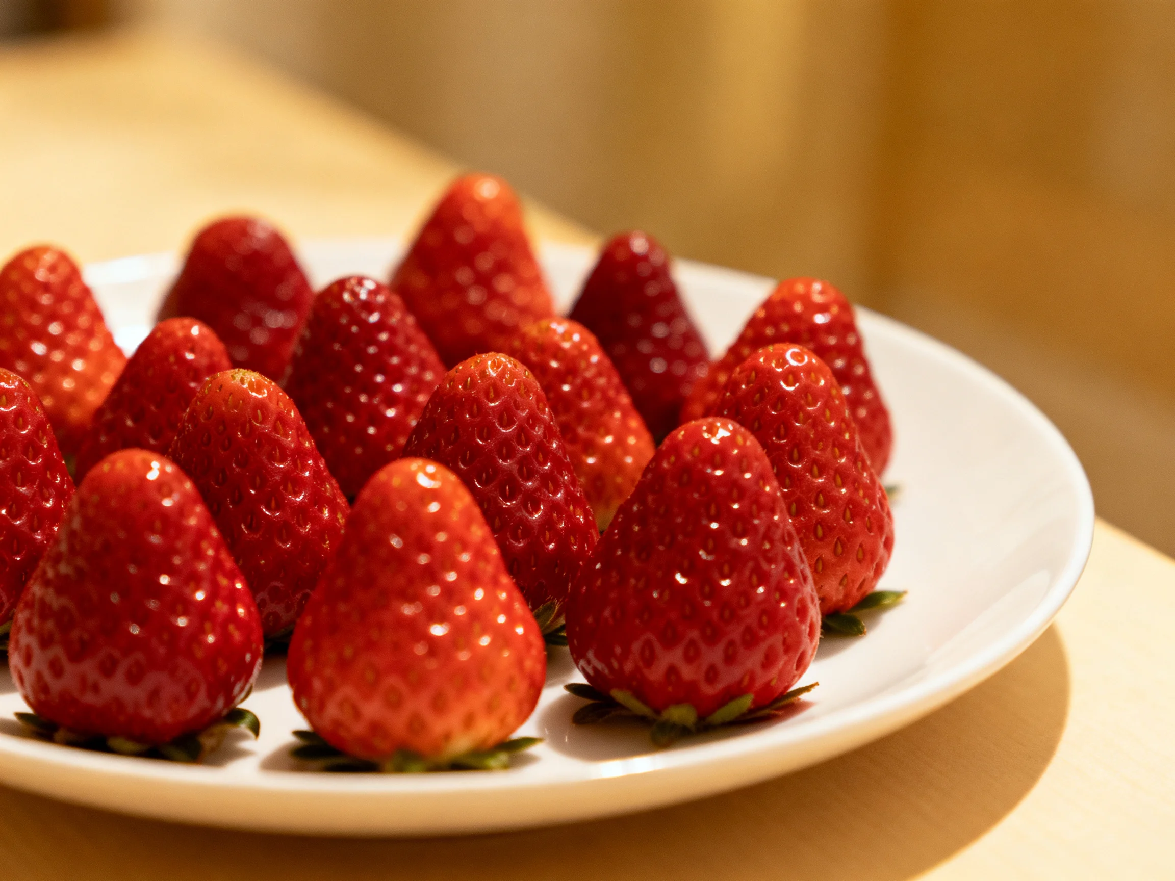 A plate of vibrant red strawberries arranged neatly