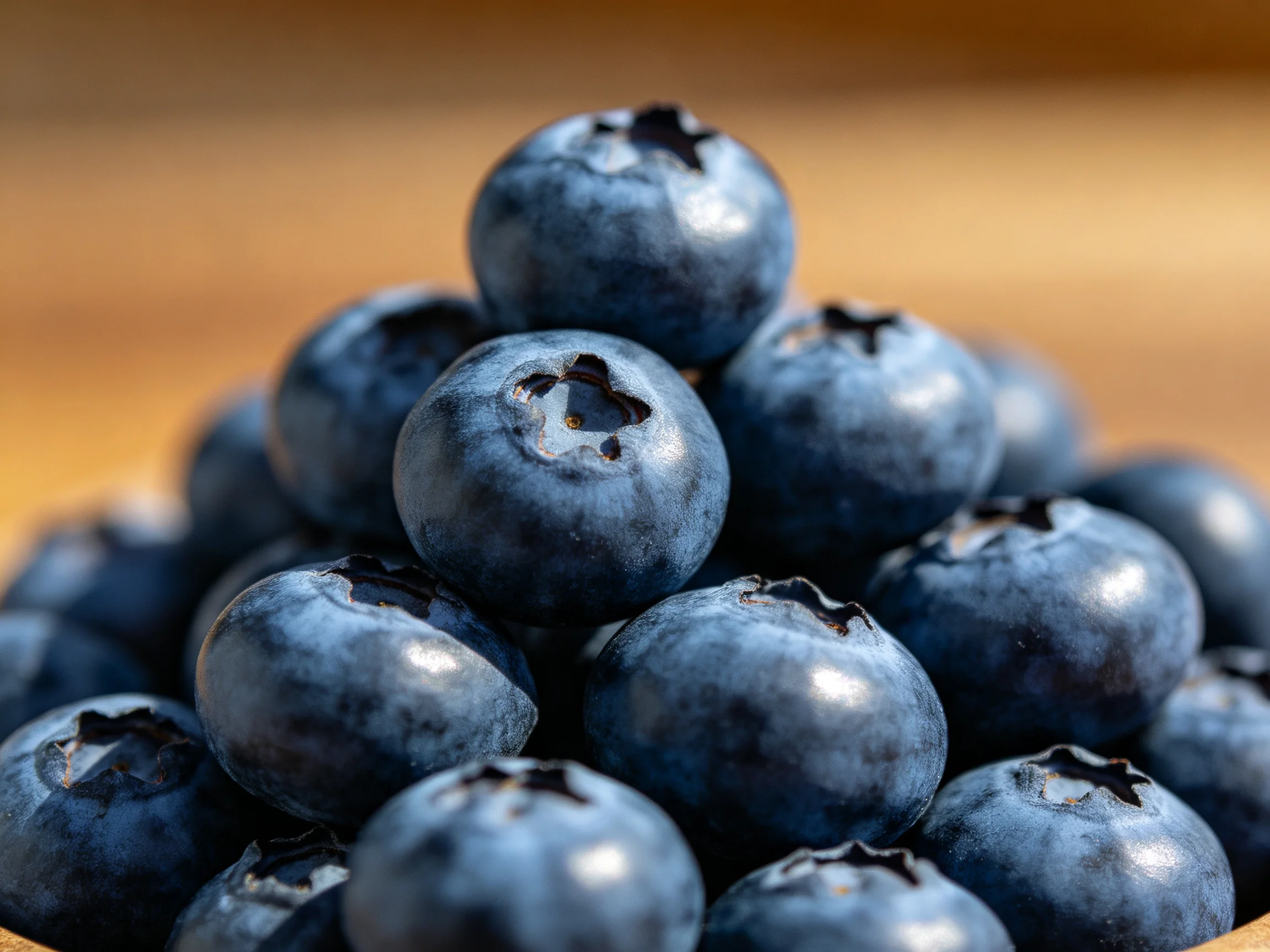 A pyramid of plump, deep-blue blueberries stacked closely together.
