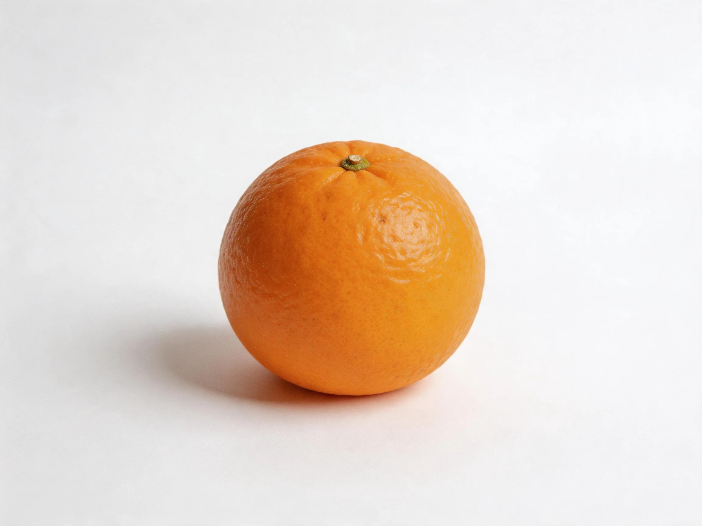 A single vibrant orange citrus fruit on a plain white surface