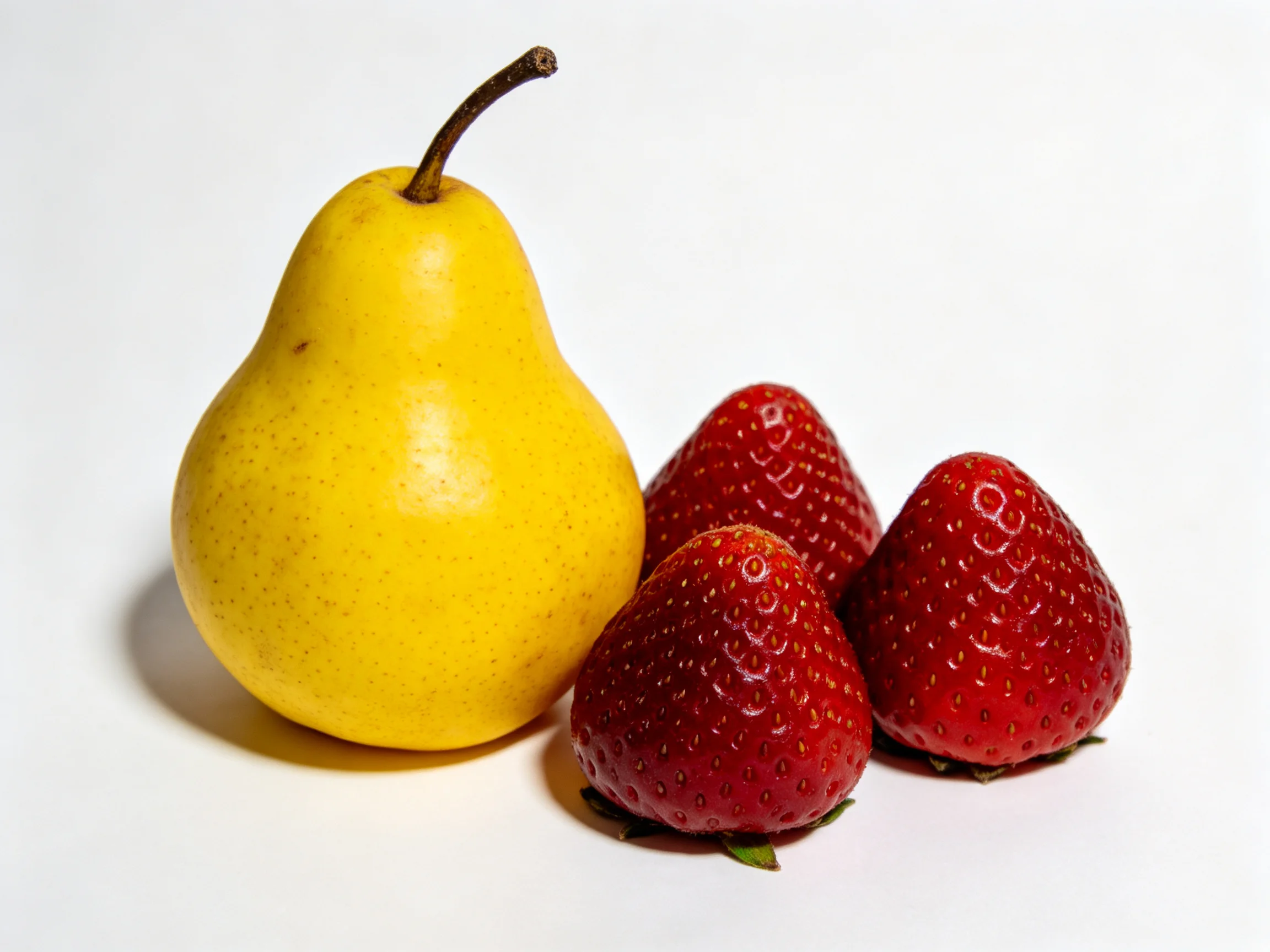 A yellow pear beside three vibrant red strawberries
