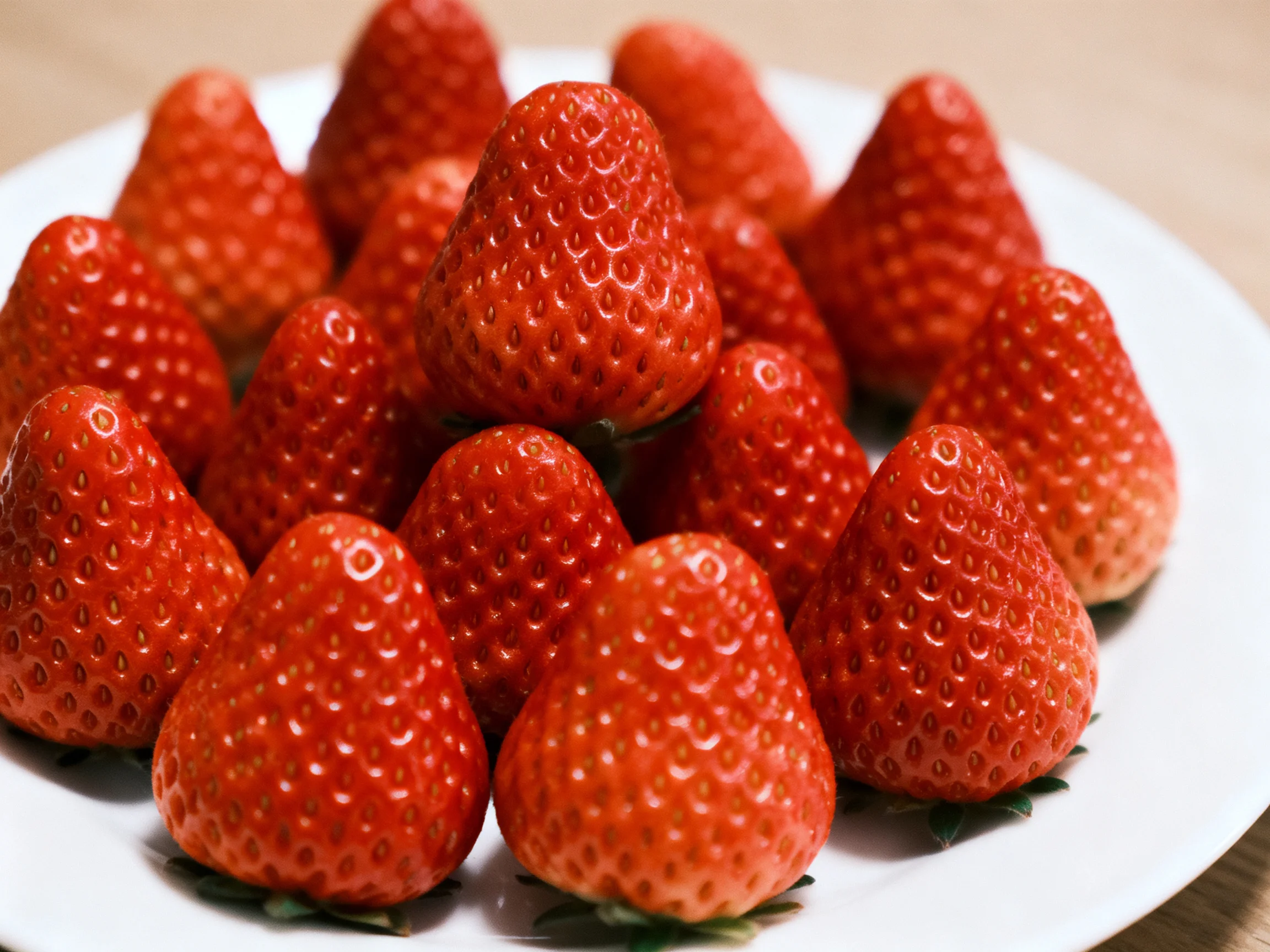 Abundant vibrant red strawberries arranged on a white plate