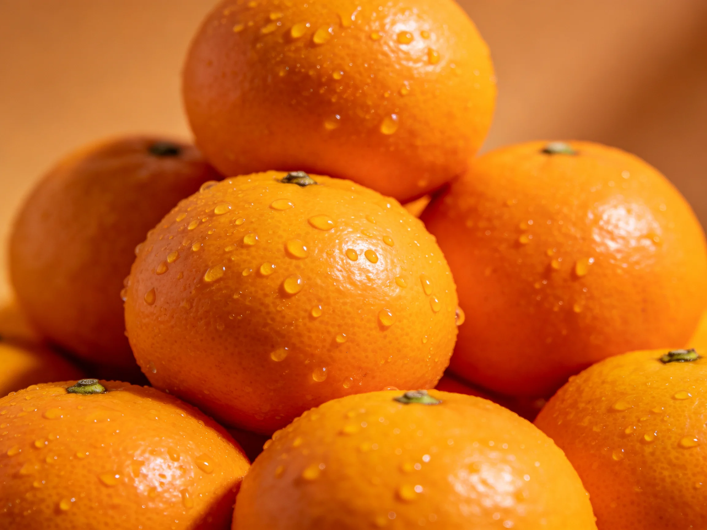 Freshly washed vibrant oranges stacked in a pyramid formation