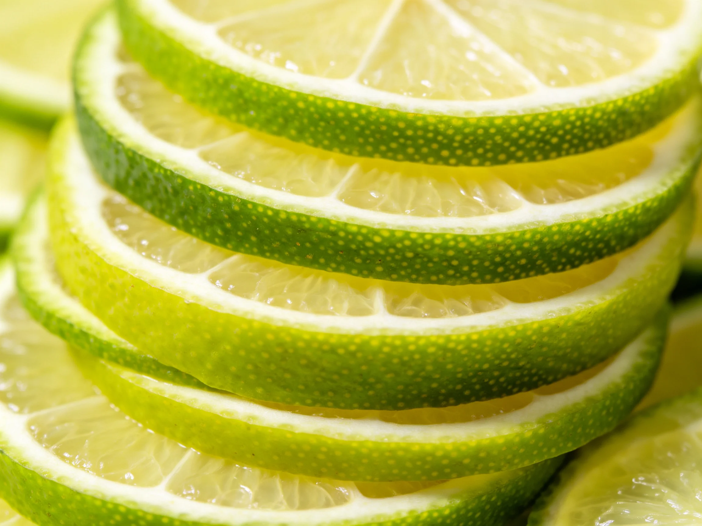 Stack of fresh lime slices with vibrant green rinds and juicy interiors