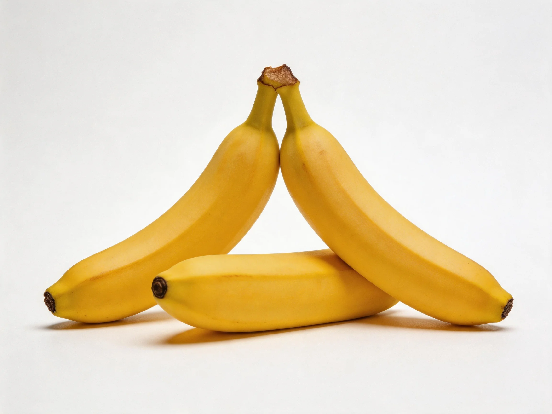 Three ripe yellow bananas arranged in a triangular formation