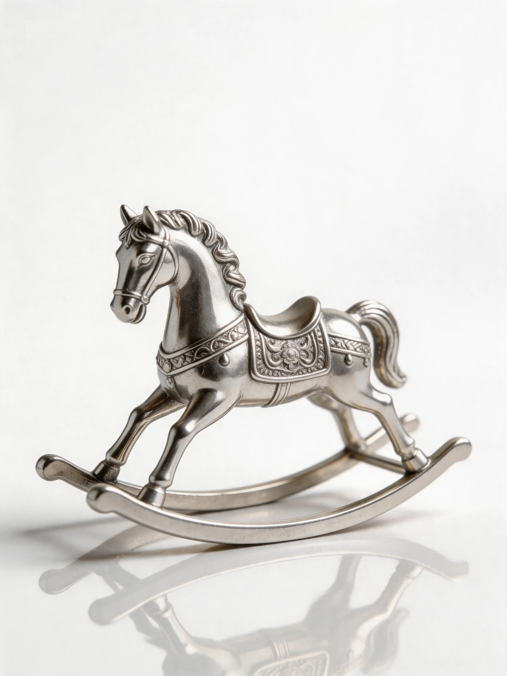A silver ornate rocking horse figurine with decorative saddle