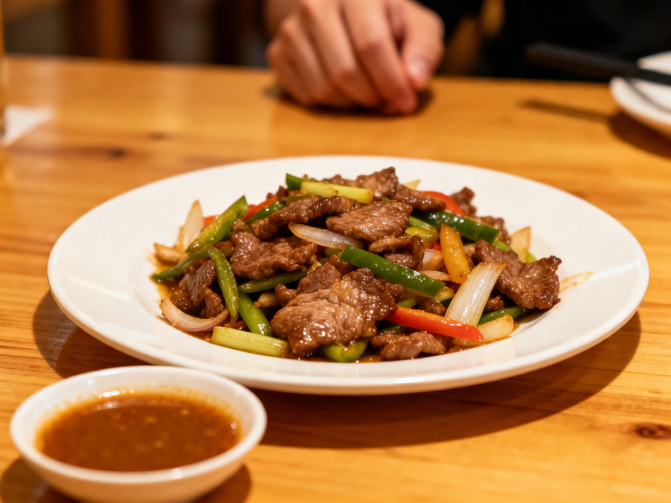 A savory beef stir - fry with colorful vegetables on a white plate