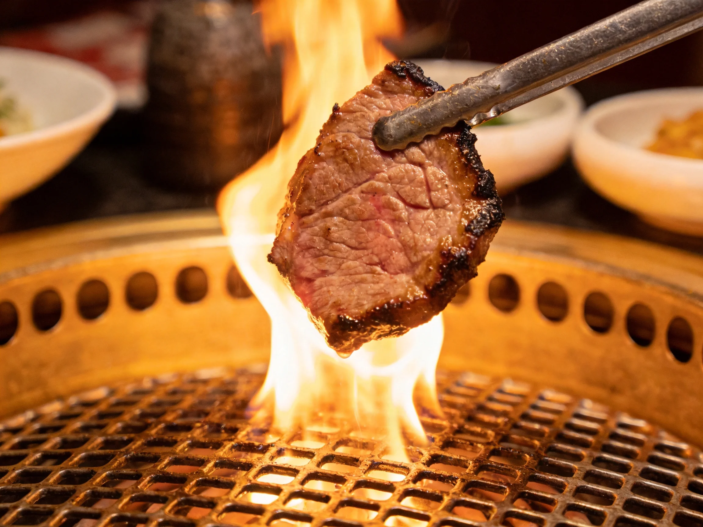 A seared beef slice grilling over vibrant flames