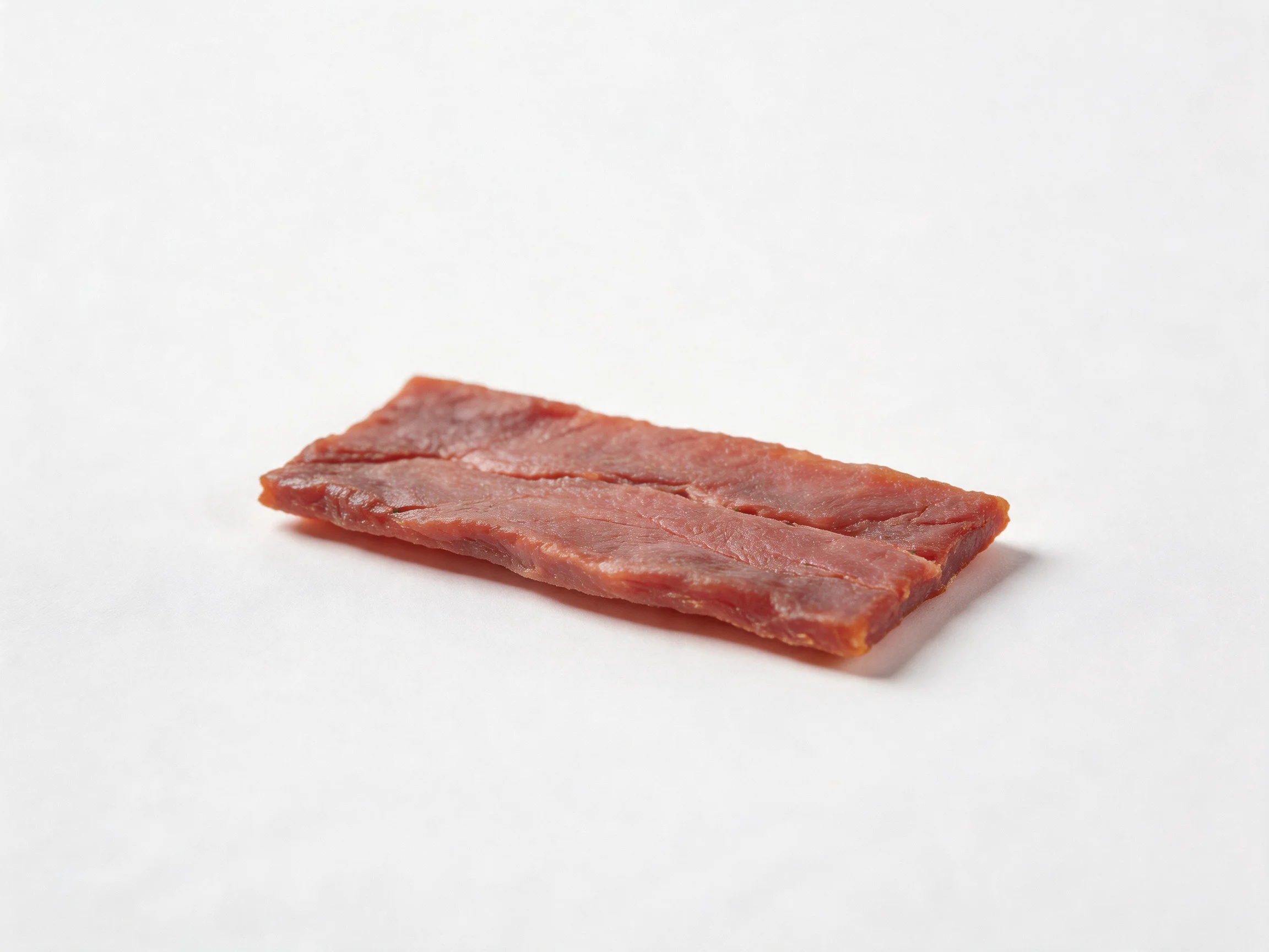 A single rectangular reddish-brown dried meat slice on white