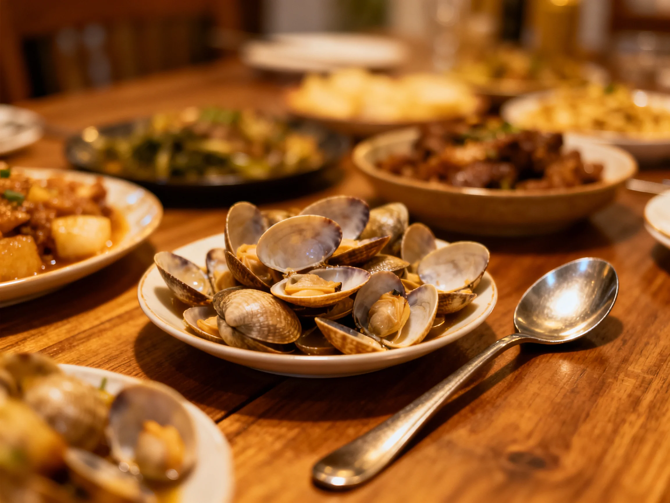 A wooden table holds assorted dishes centered around clams