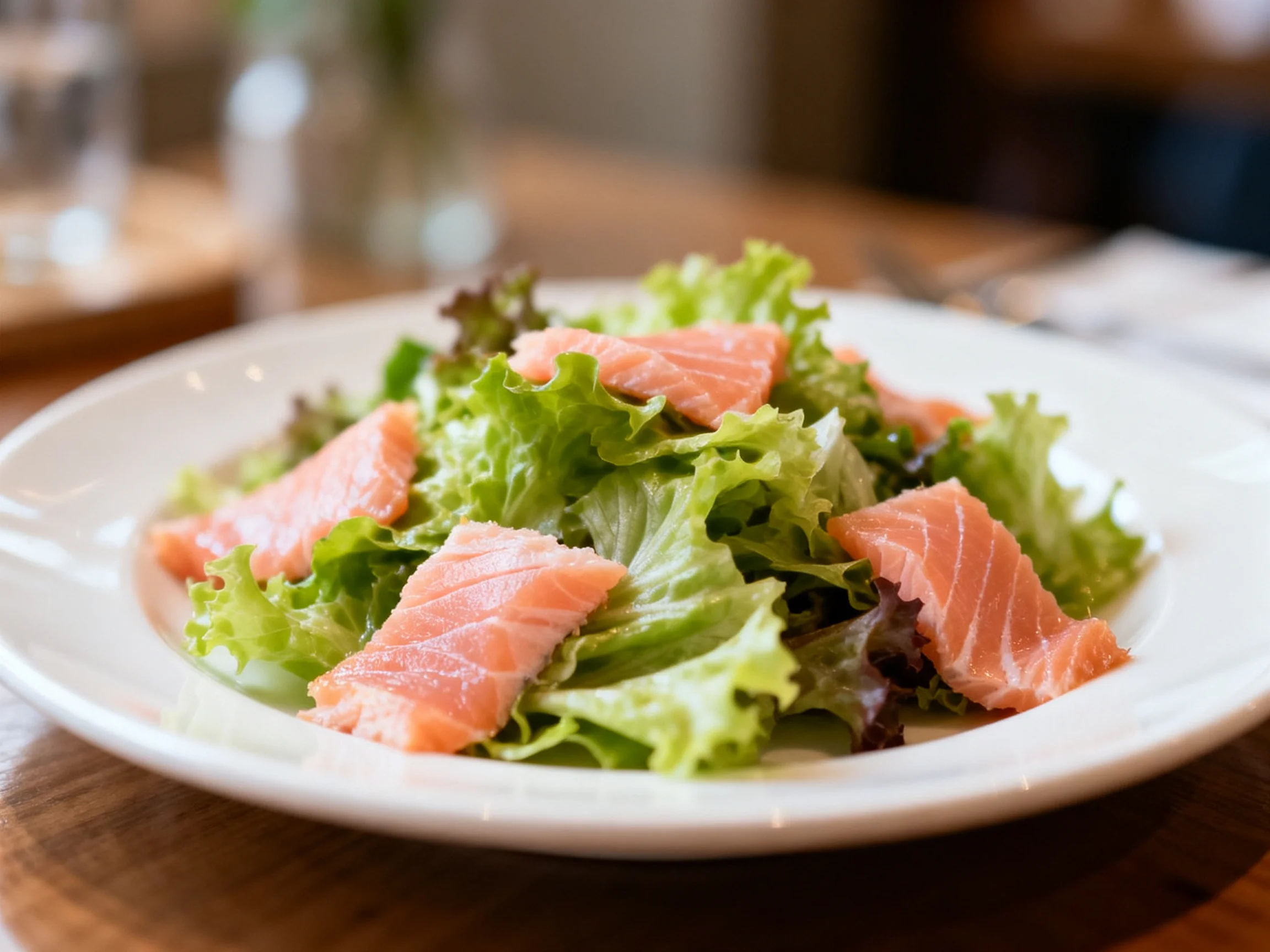 Fresh Salmon Salad with Mixed Greens on a White Plate