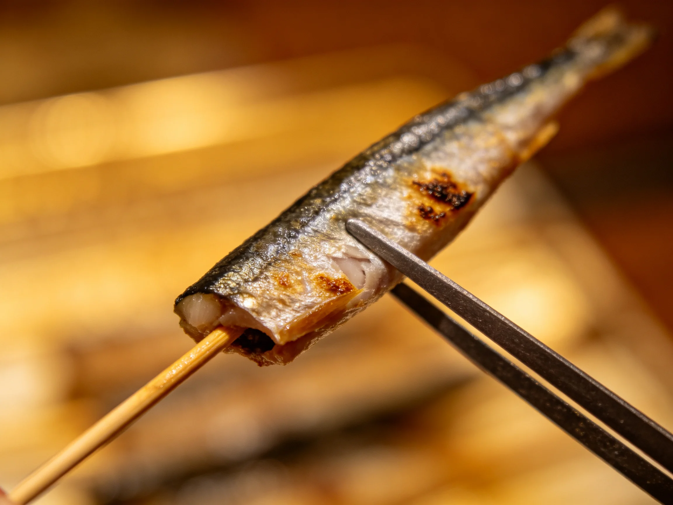 Grilled sardine on wooden skewer with metal chopstick