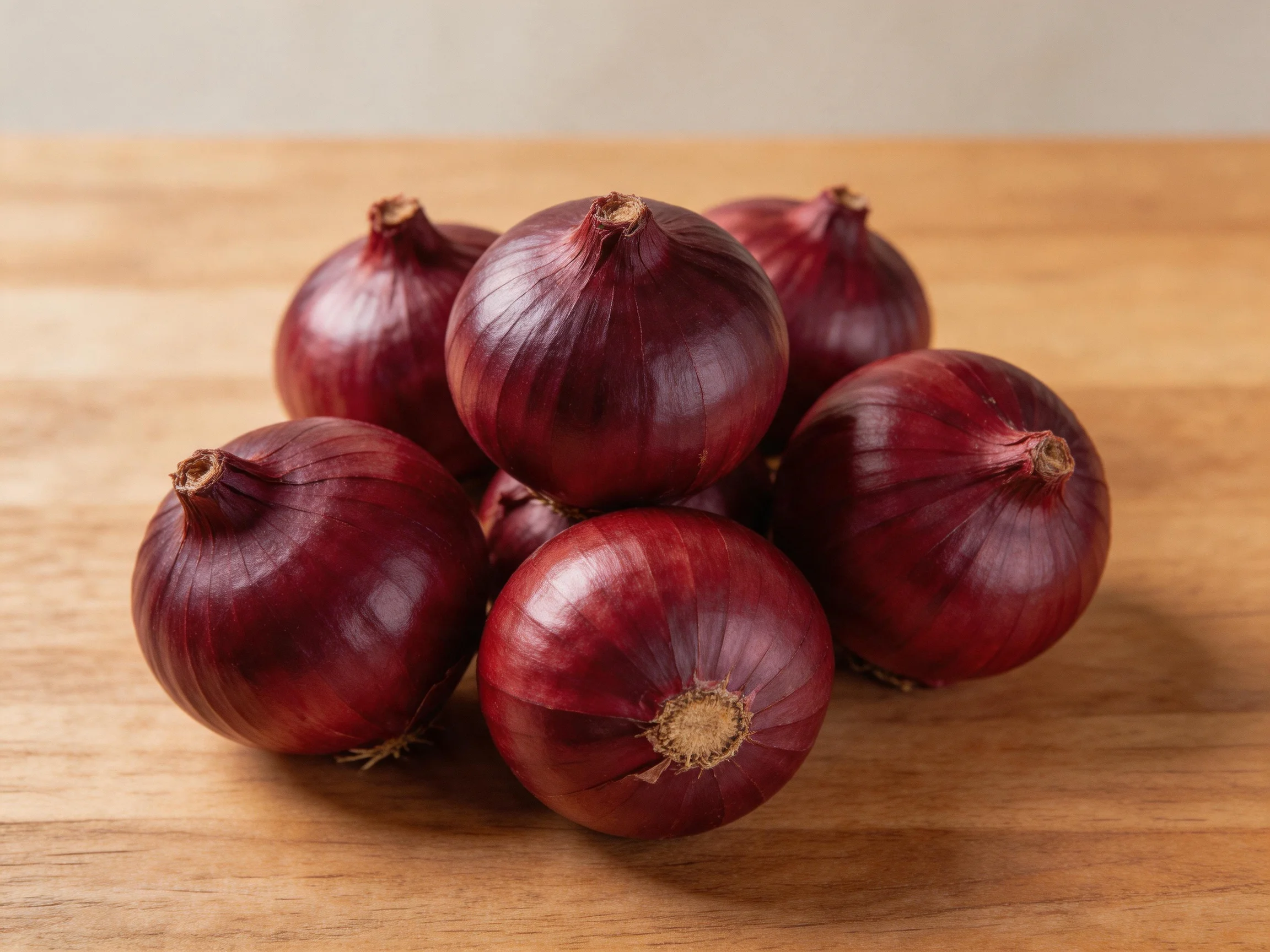 A cluster of deep red onions gathered on a wooden table