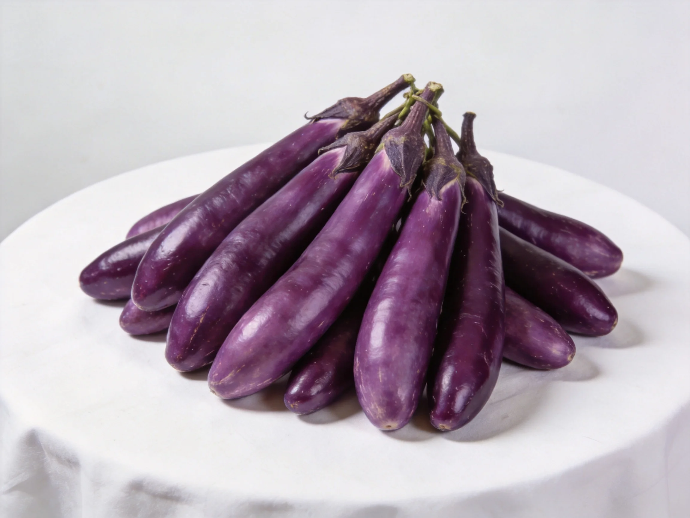 A cluster of glossy purple eggplants on a white plate