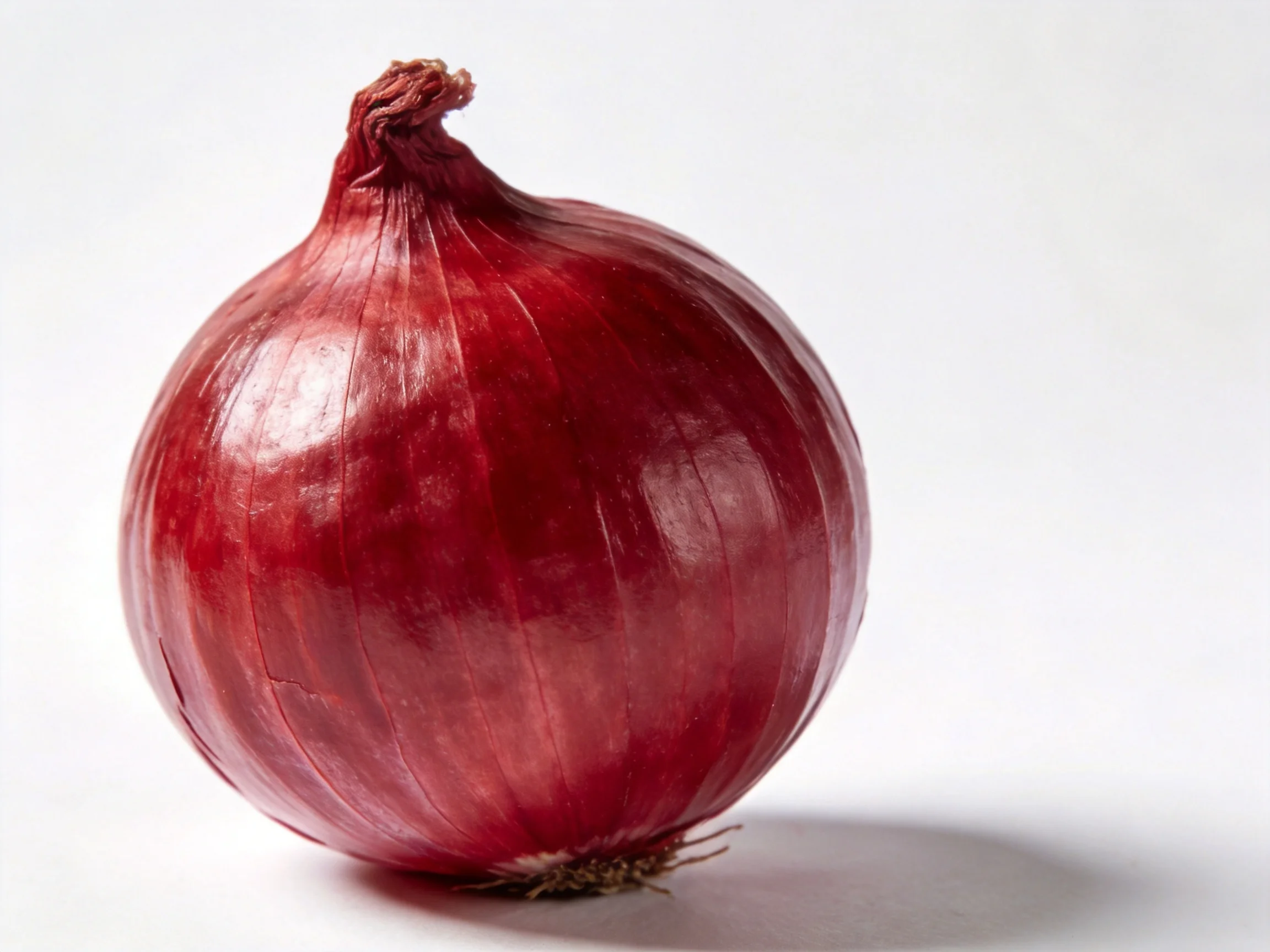 A large glossy red onion with smooth papery skin