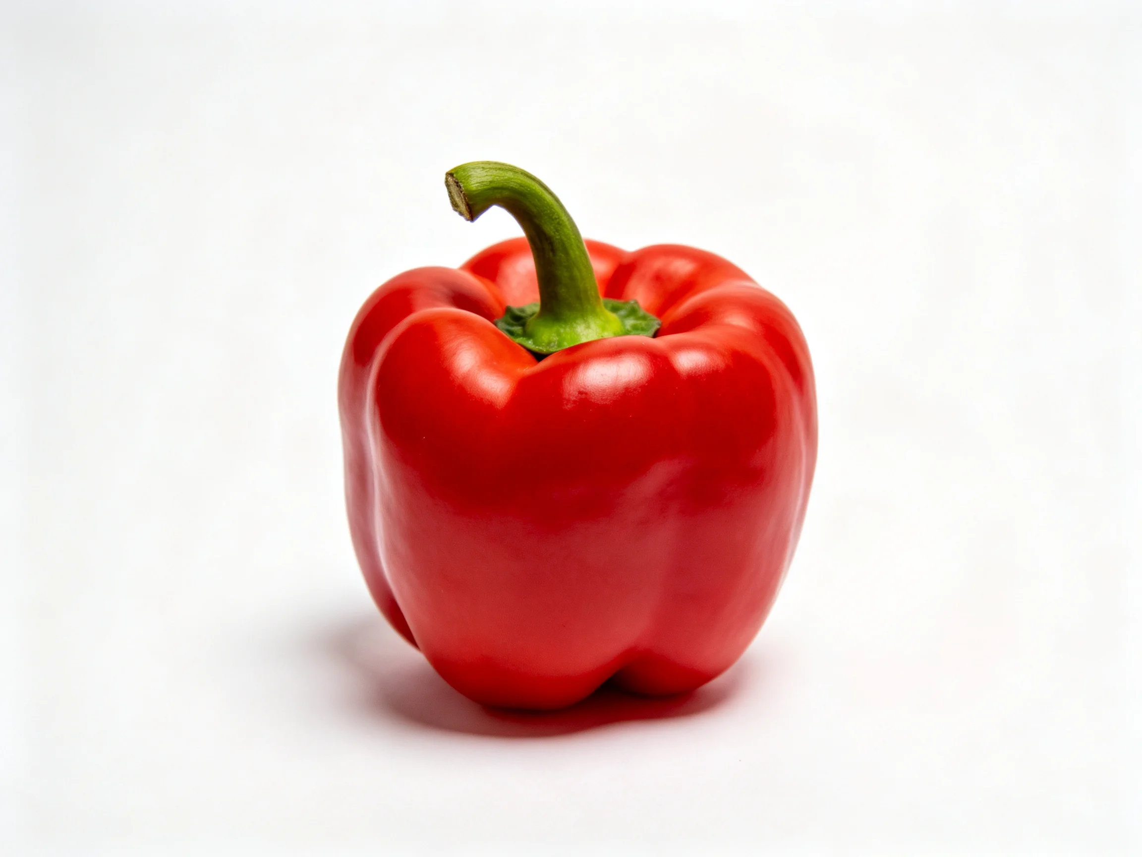 A vibrant red bell pepper with a curved green stem