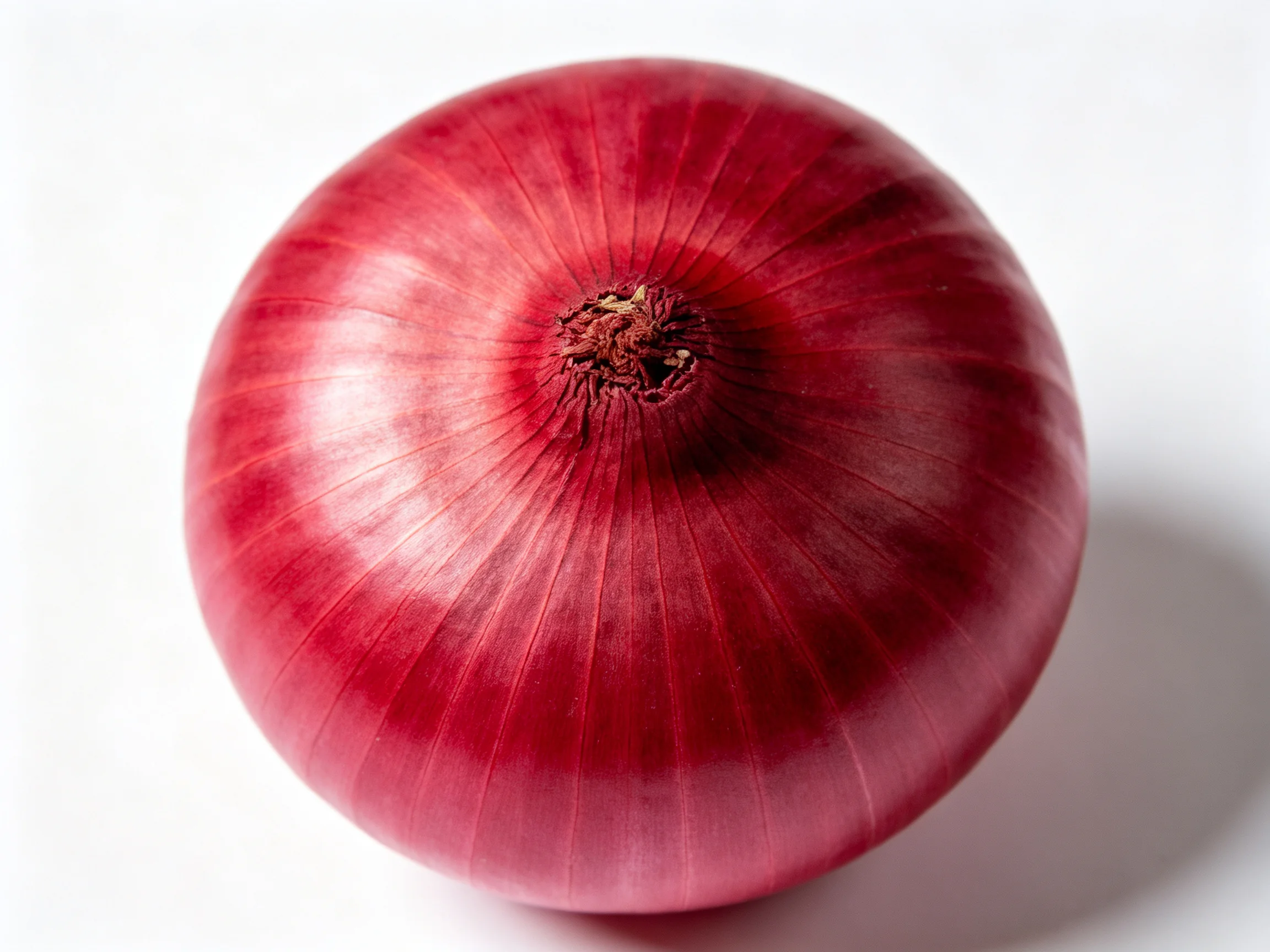 A whole red onion with smooth, glossy, reddish-purple skin