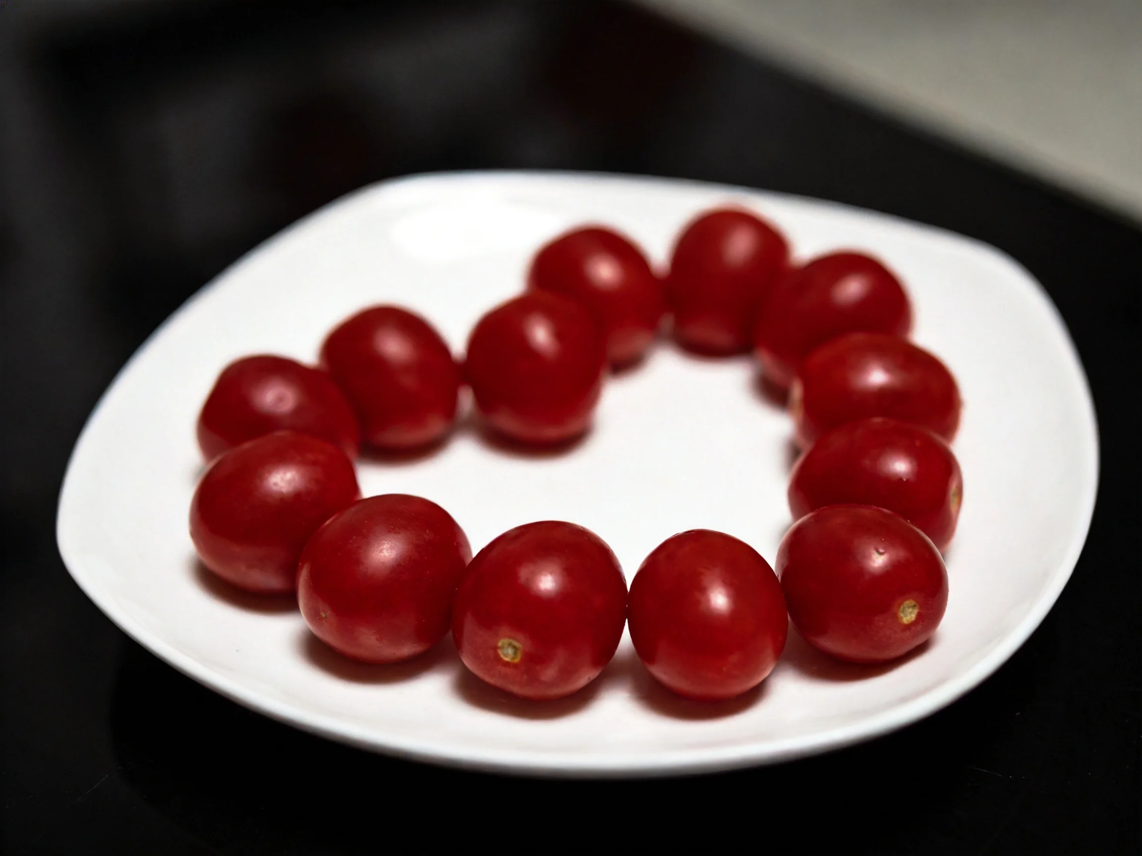 Cherry tomatoes arranged in a heart shape on a white plate