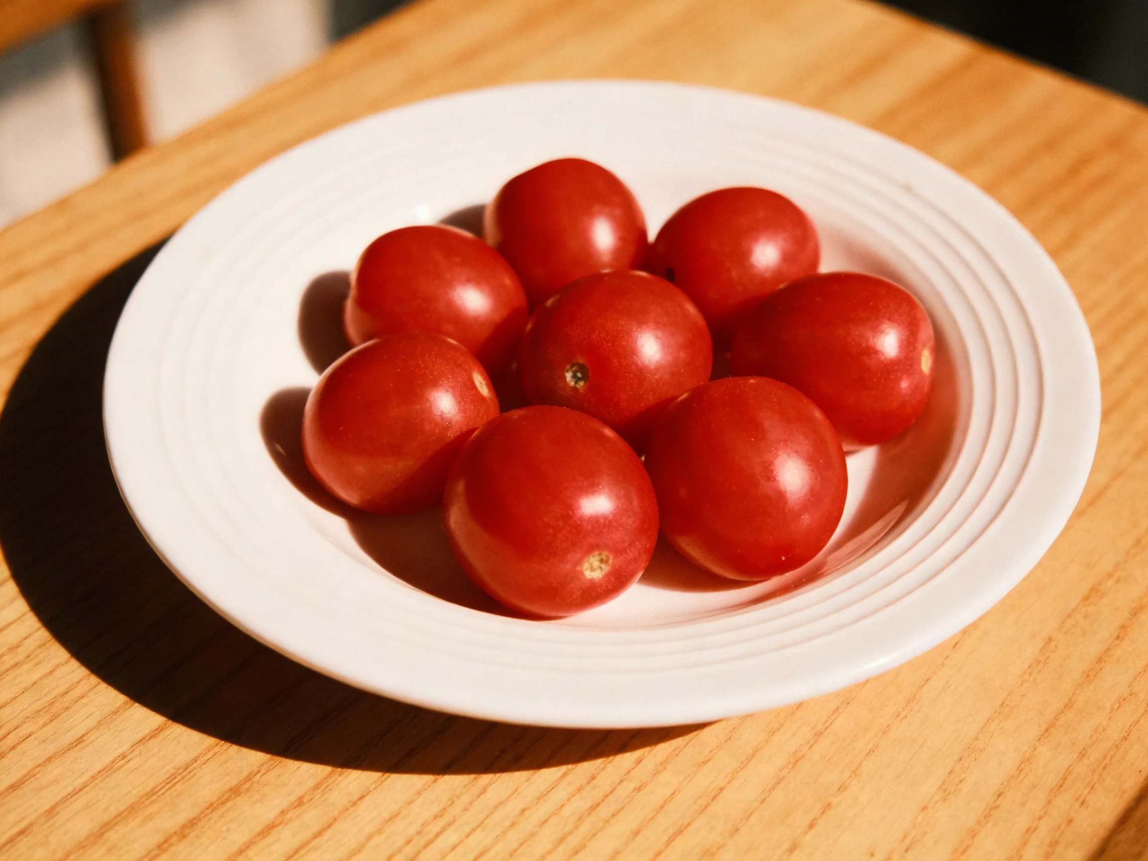 Cherry tomatoes arranged ina white plate on a wooden surface