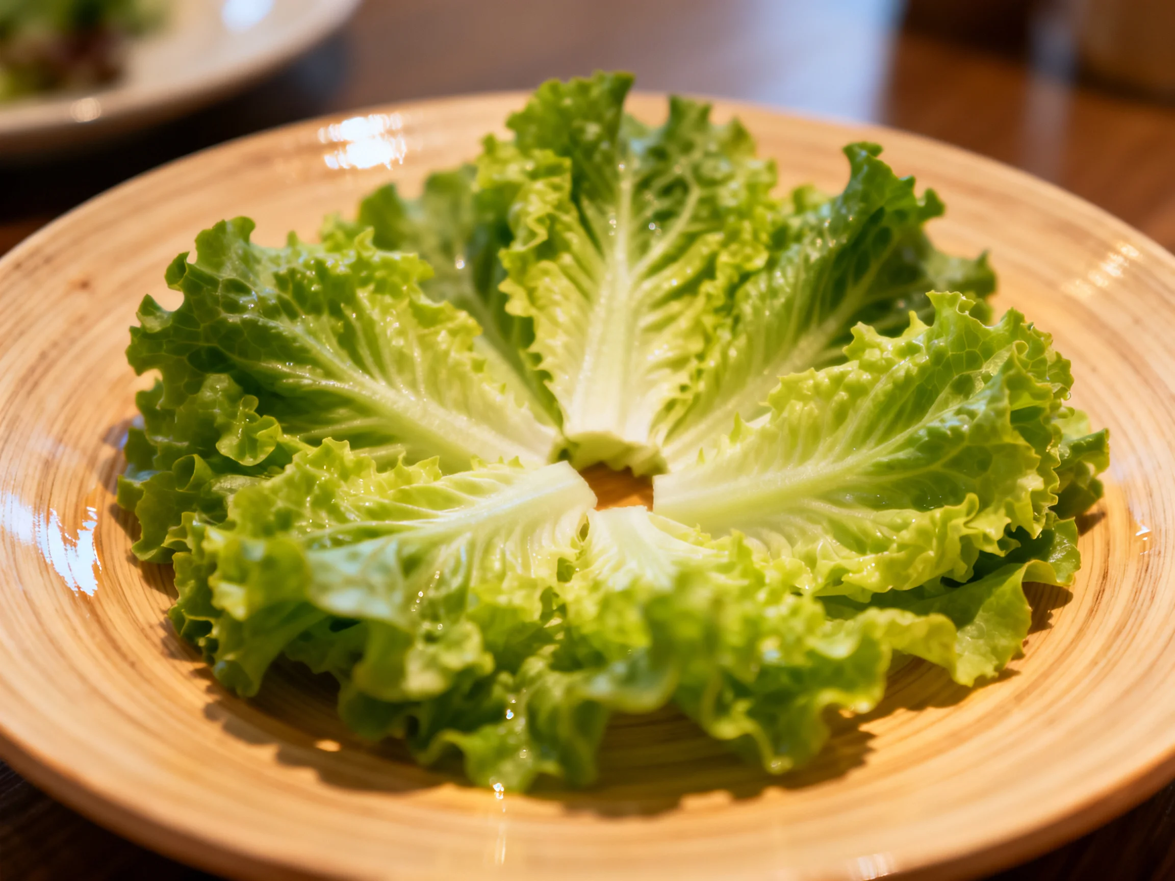 Circular arrangement of fresh green lettuce on a wooden plate