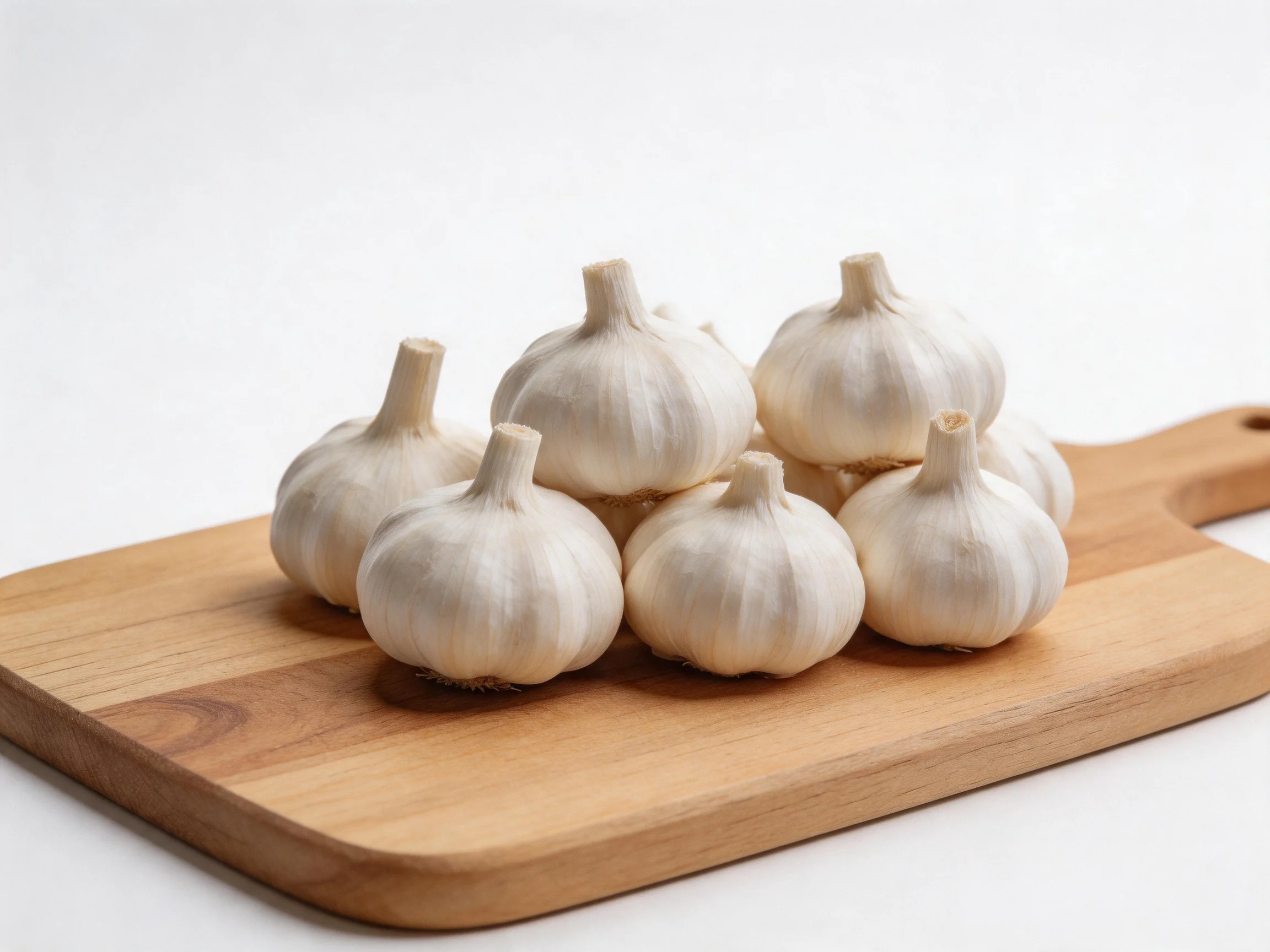 Eight garlic bulbs arranged on a light brown wooden cutting board