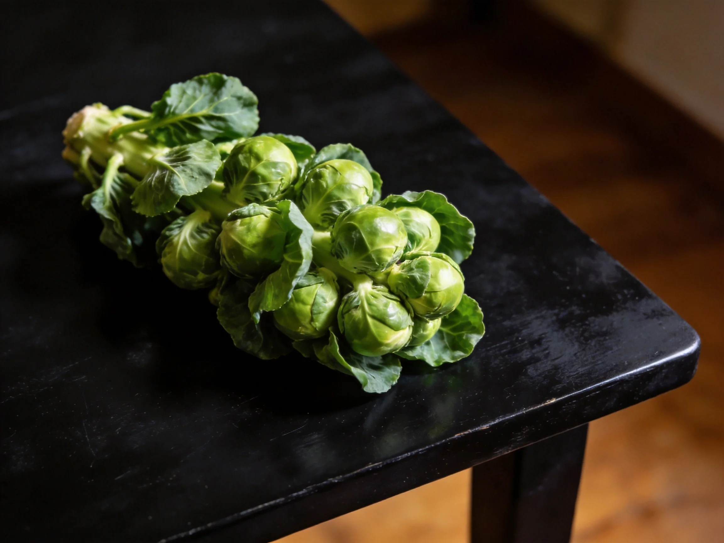 Fresh green Brussels sprouts cluster on a glossy black table