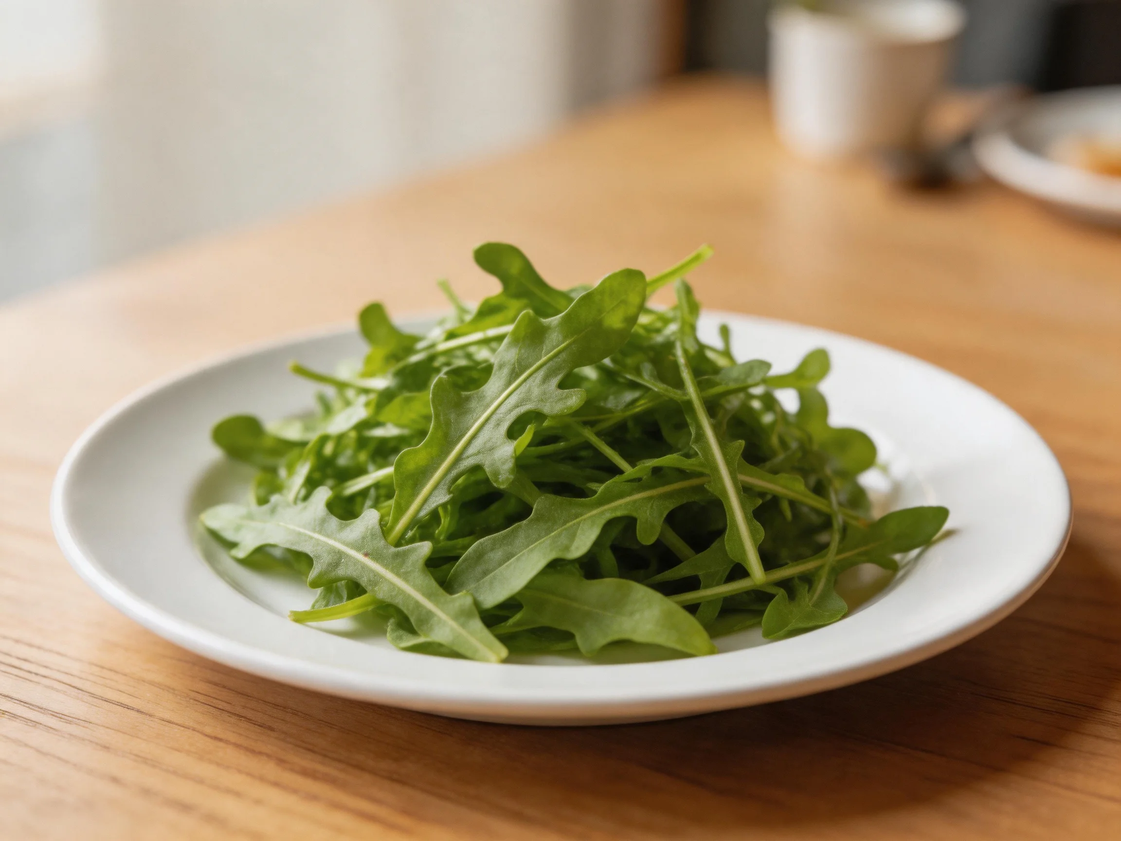 Fresh green arugula arranged on a white plate atop a wooden table