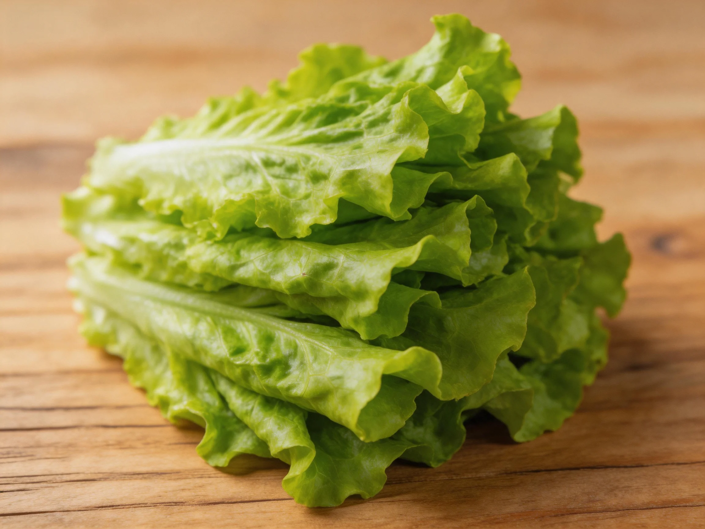 Fresh green lettuce leaves stacked on a wooden cutting board