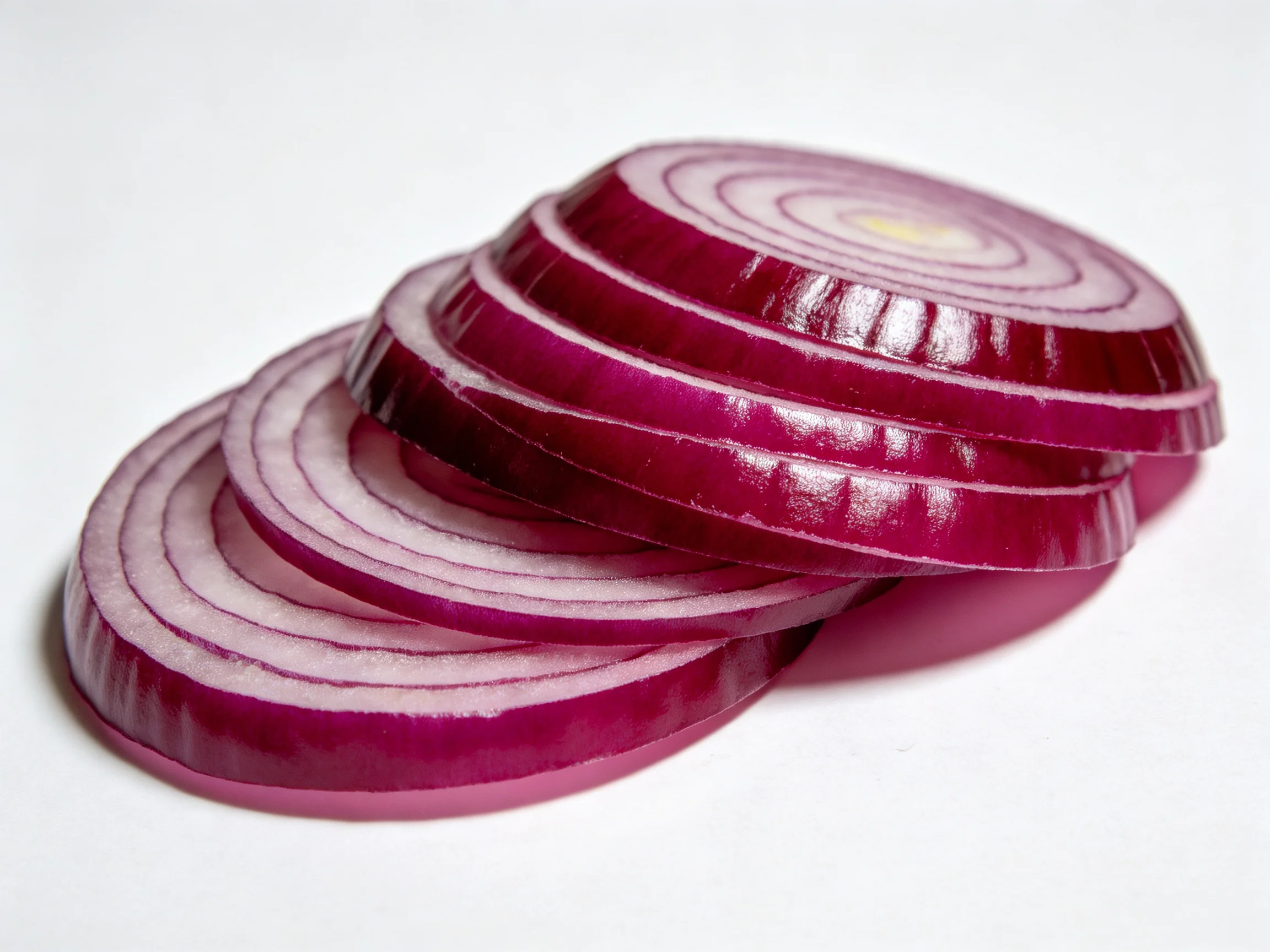 Sliced red onion rings stacked, displaying vibrant purple and white concentric layers